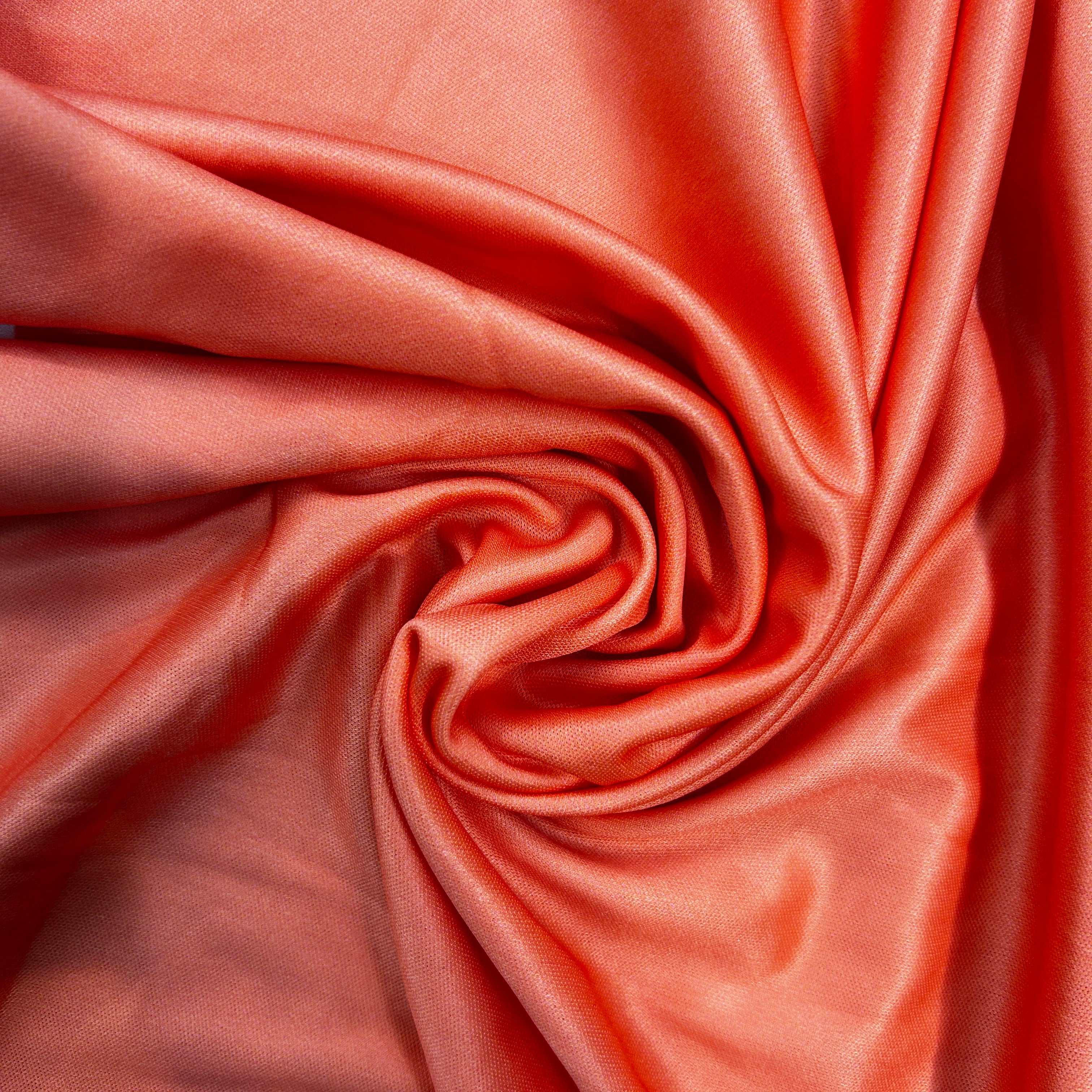 Close-up of pink satin fabric with folds