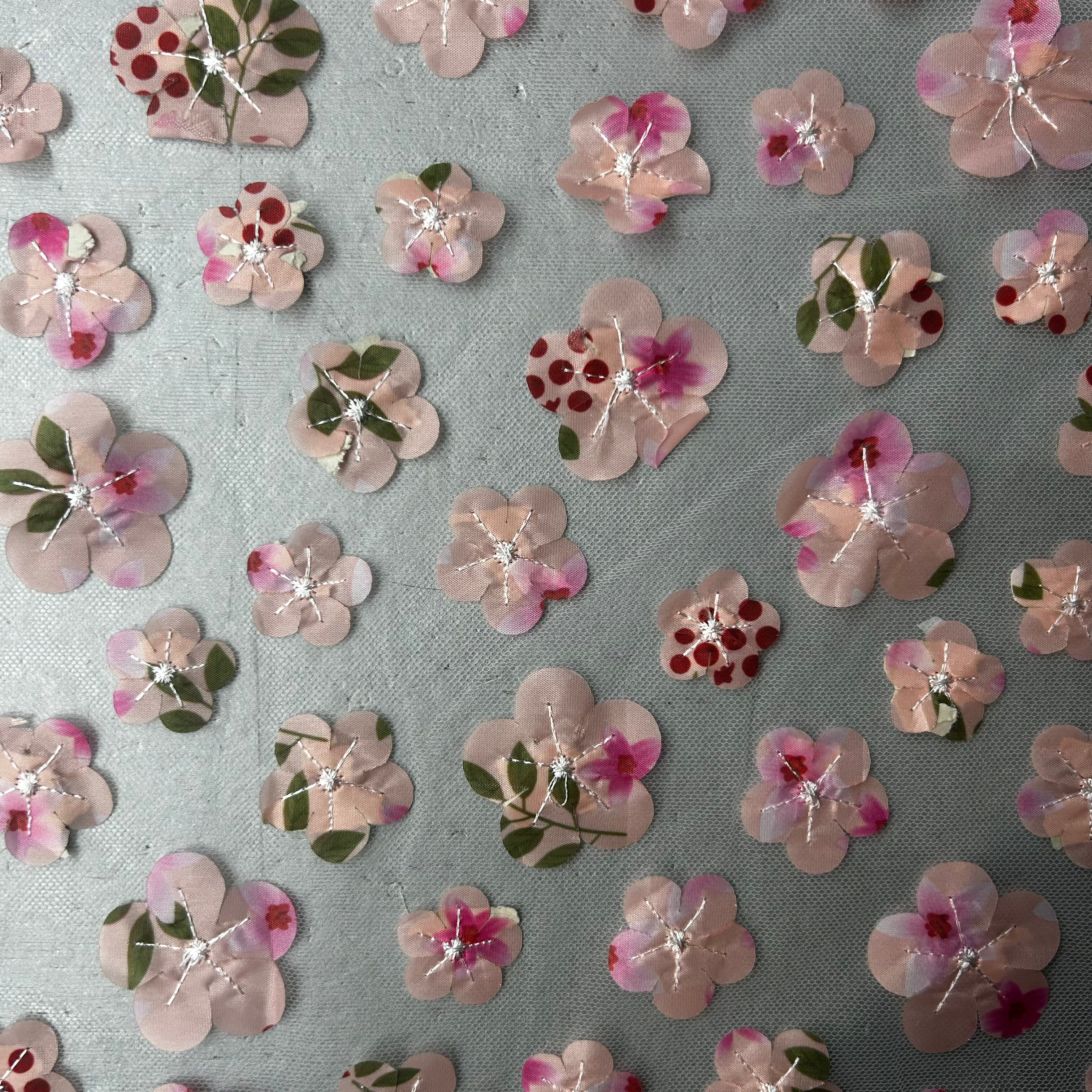 Pattern of pink floral stickers on a gray background