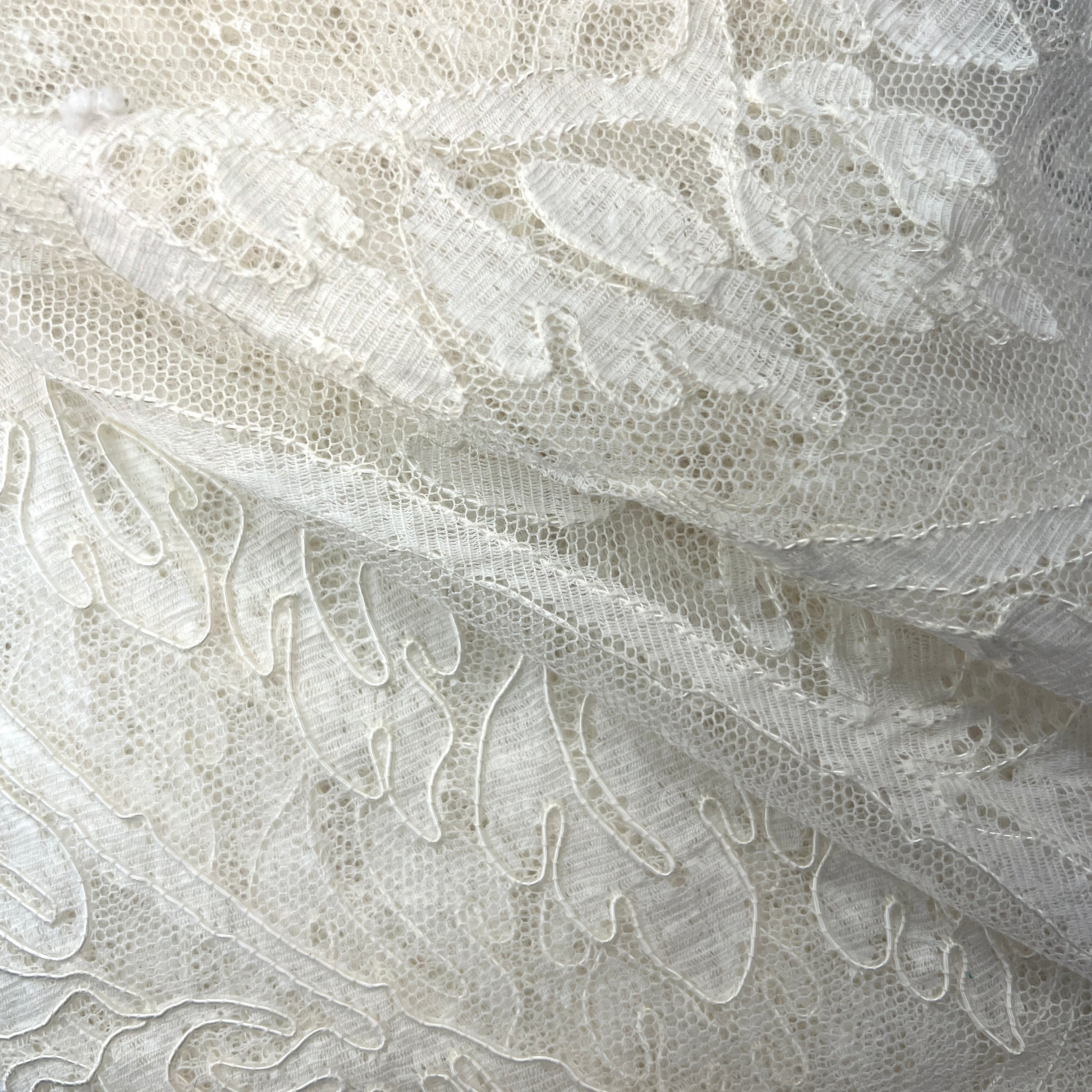 Close-up of white lace fabric with intricate patterns