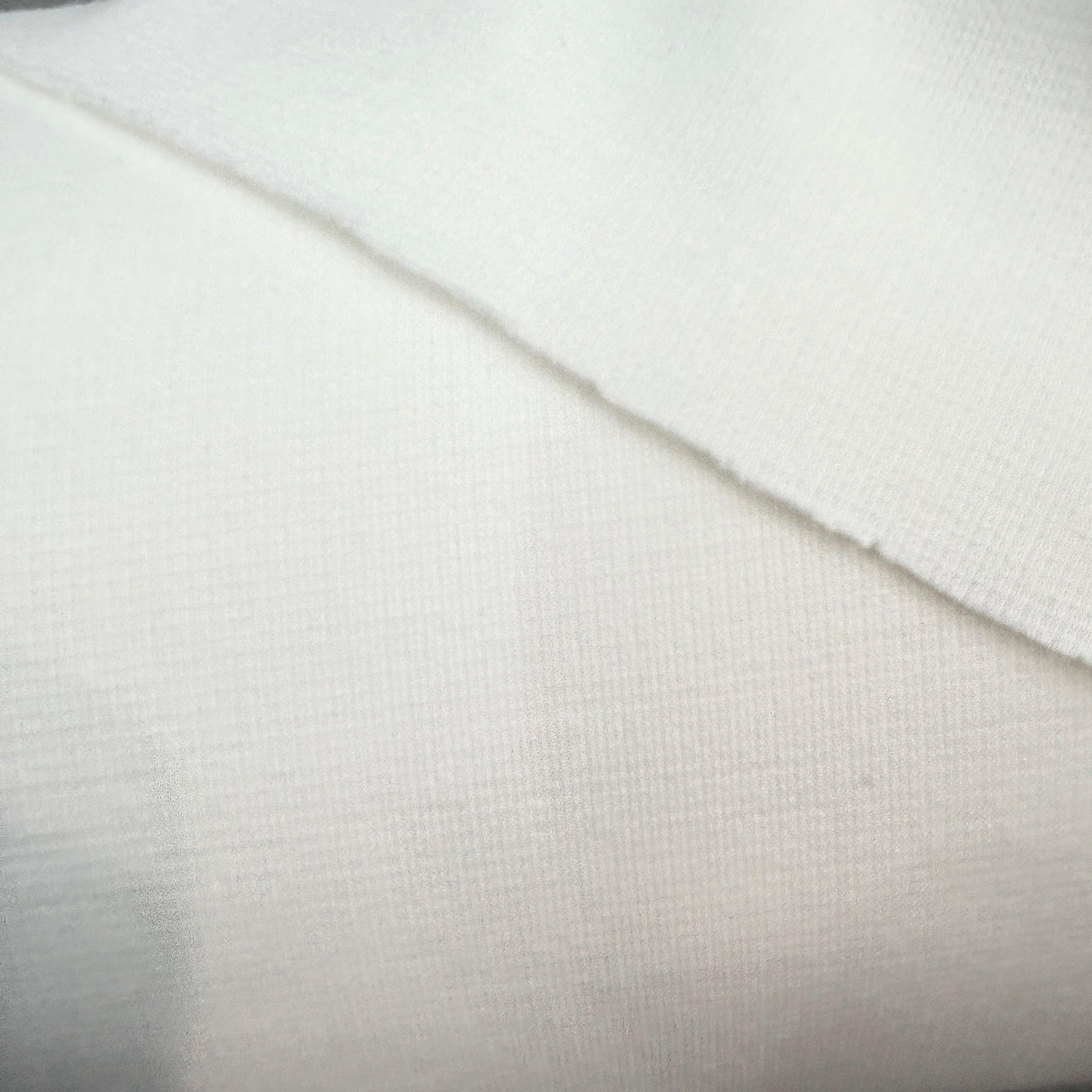 Close-up of a textured white fabric with a diagonal line