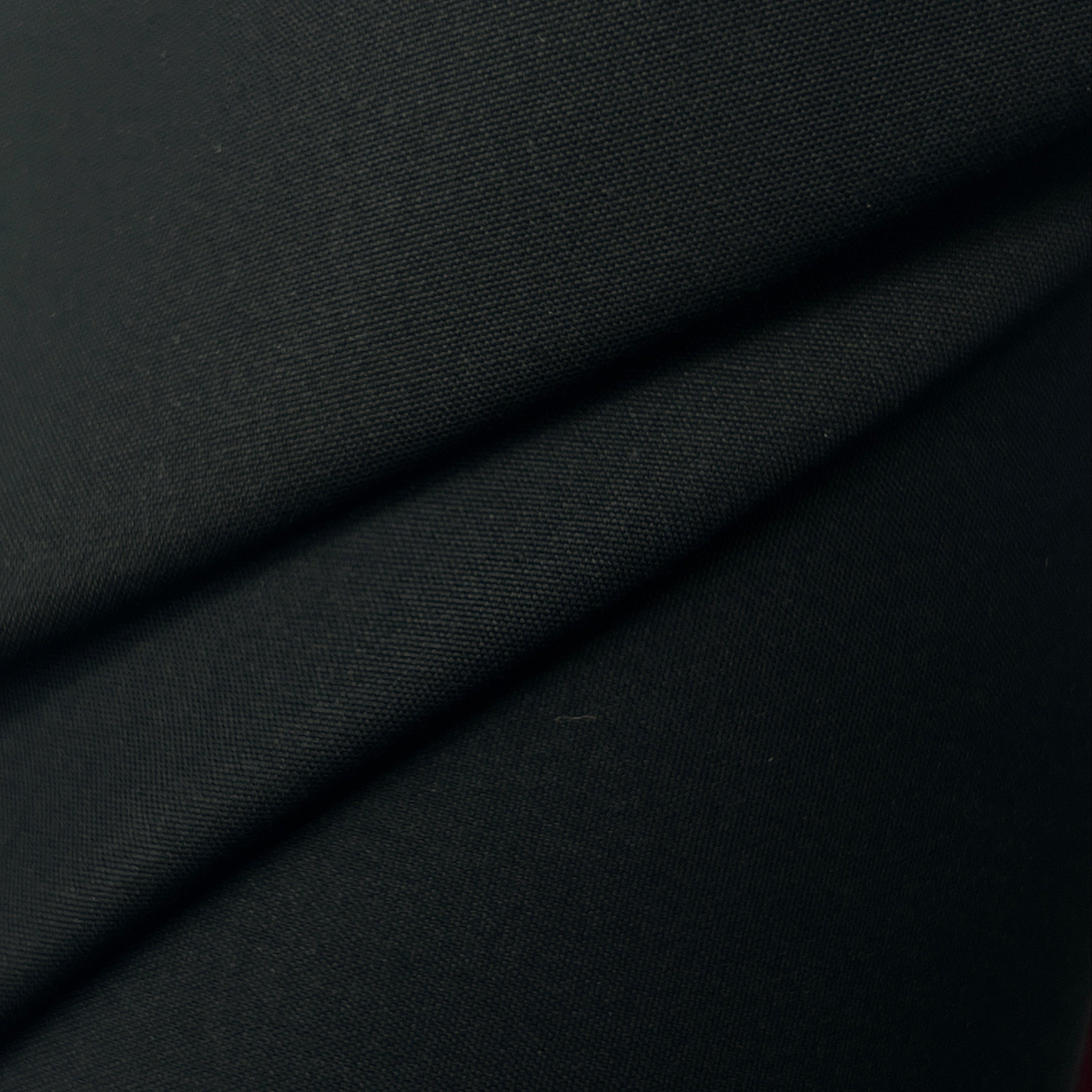 Close-up of black fabric with a diagonal seam