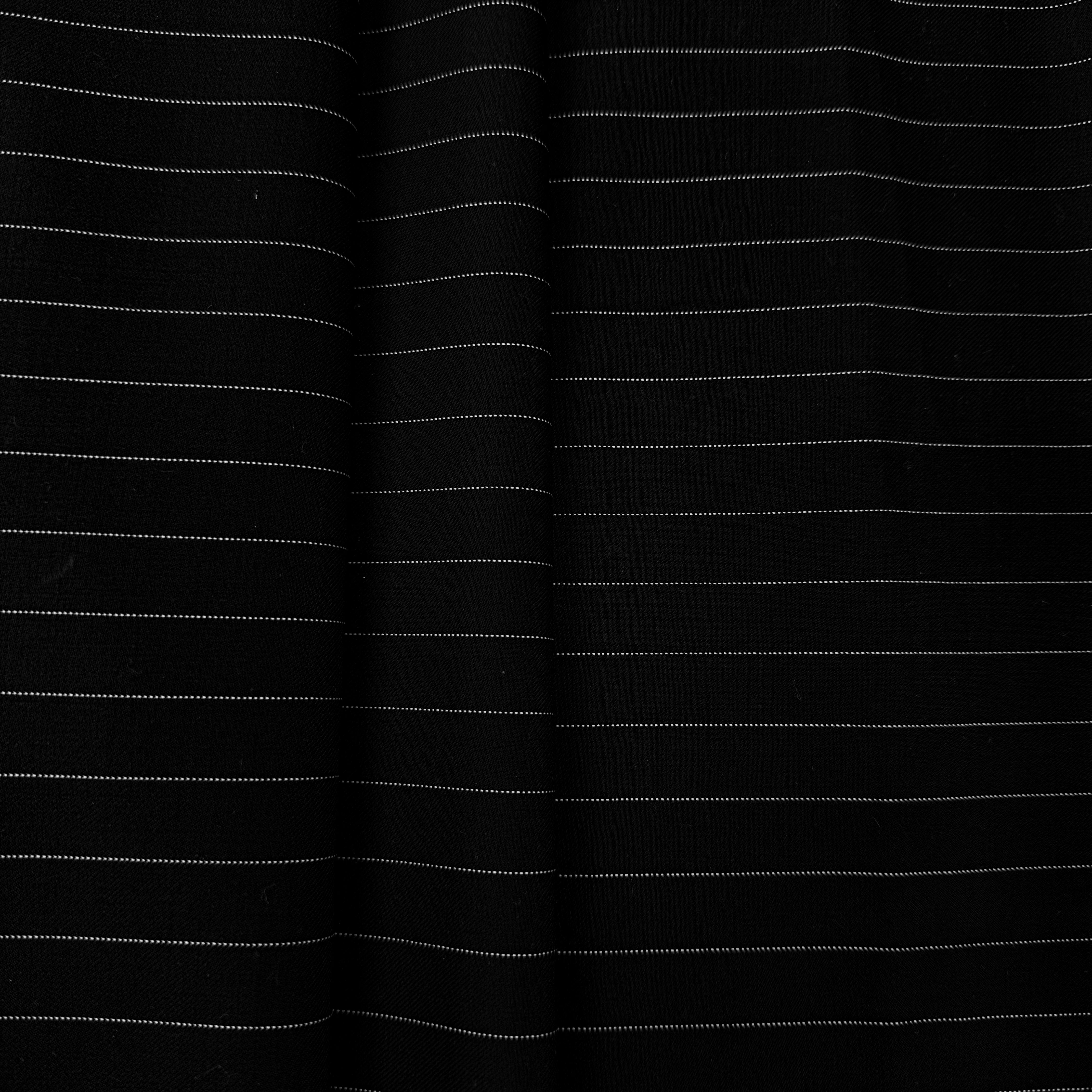 Black fabric with thin white pinstripes, shown in soft vertical folds.