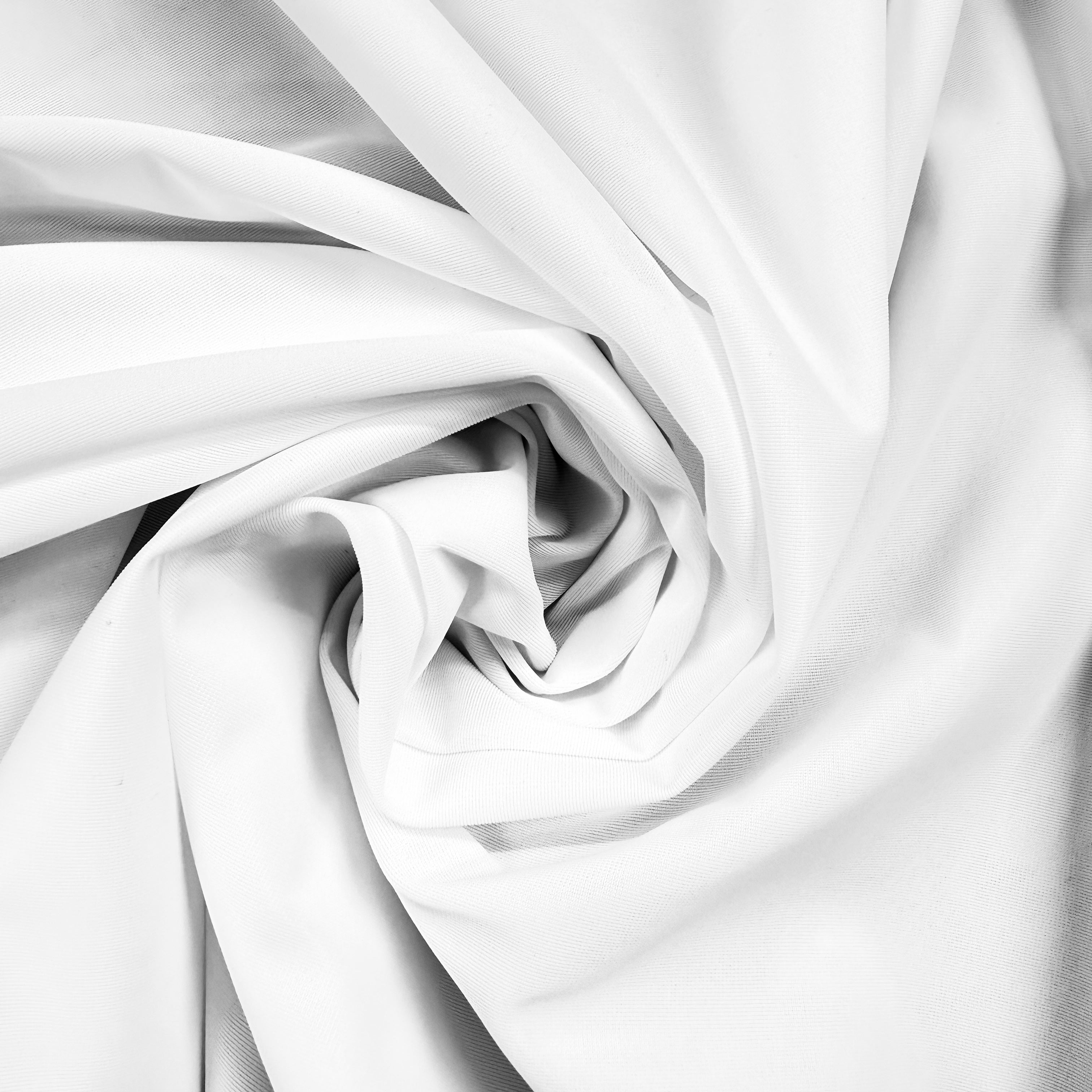 White fabric draped in a spiral swirl pattern, showing soft folds and texture.