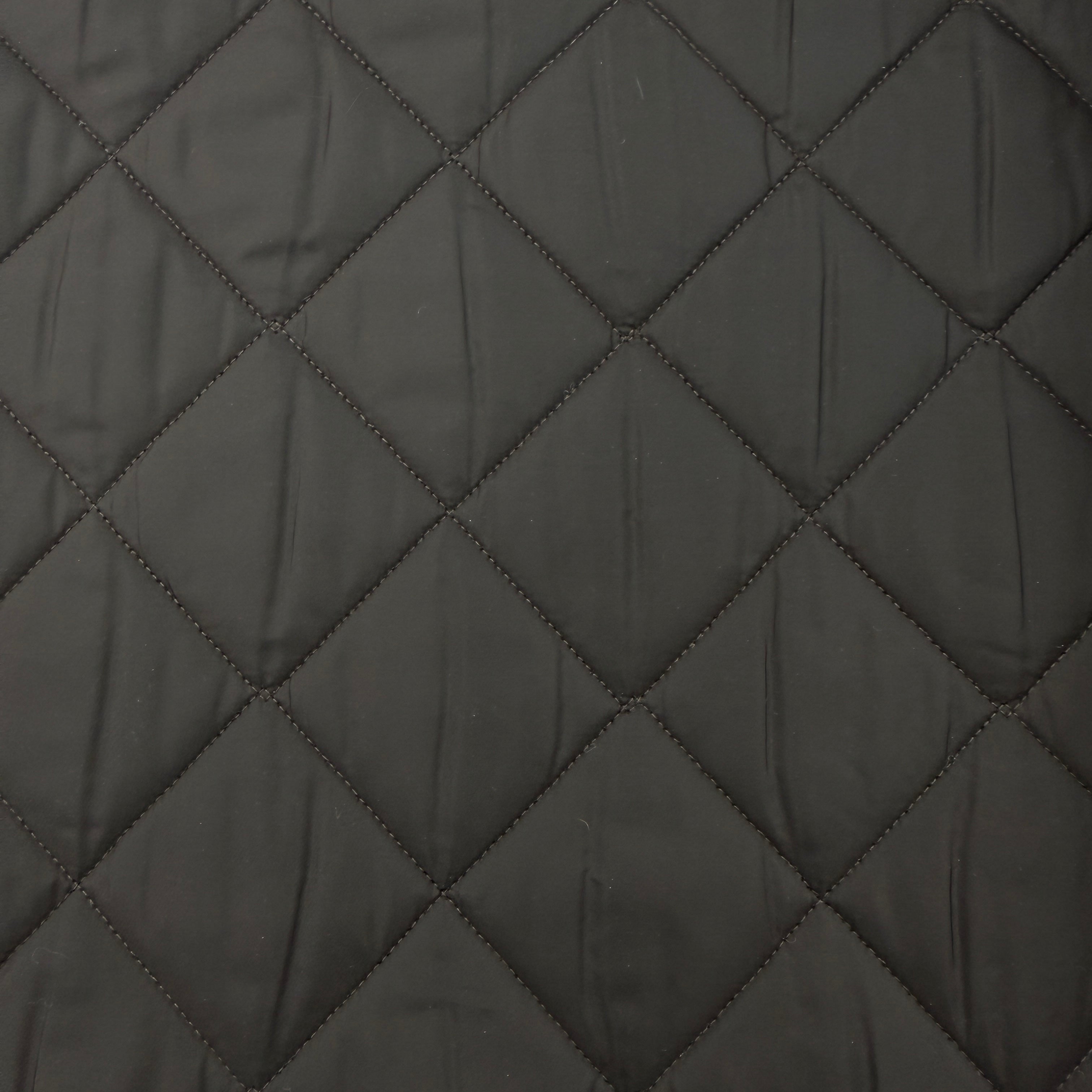 Close-up of a dark gray quilted fabric with a diamond pattern stitched seam.
