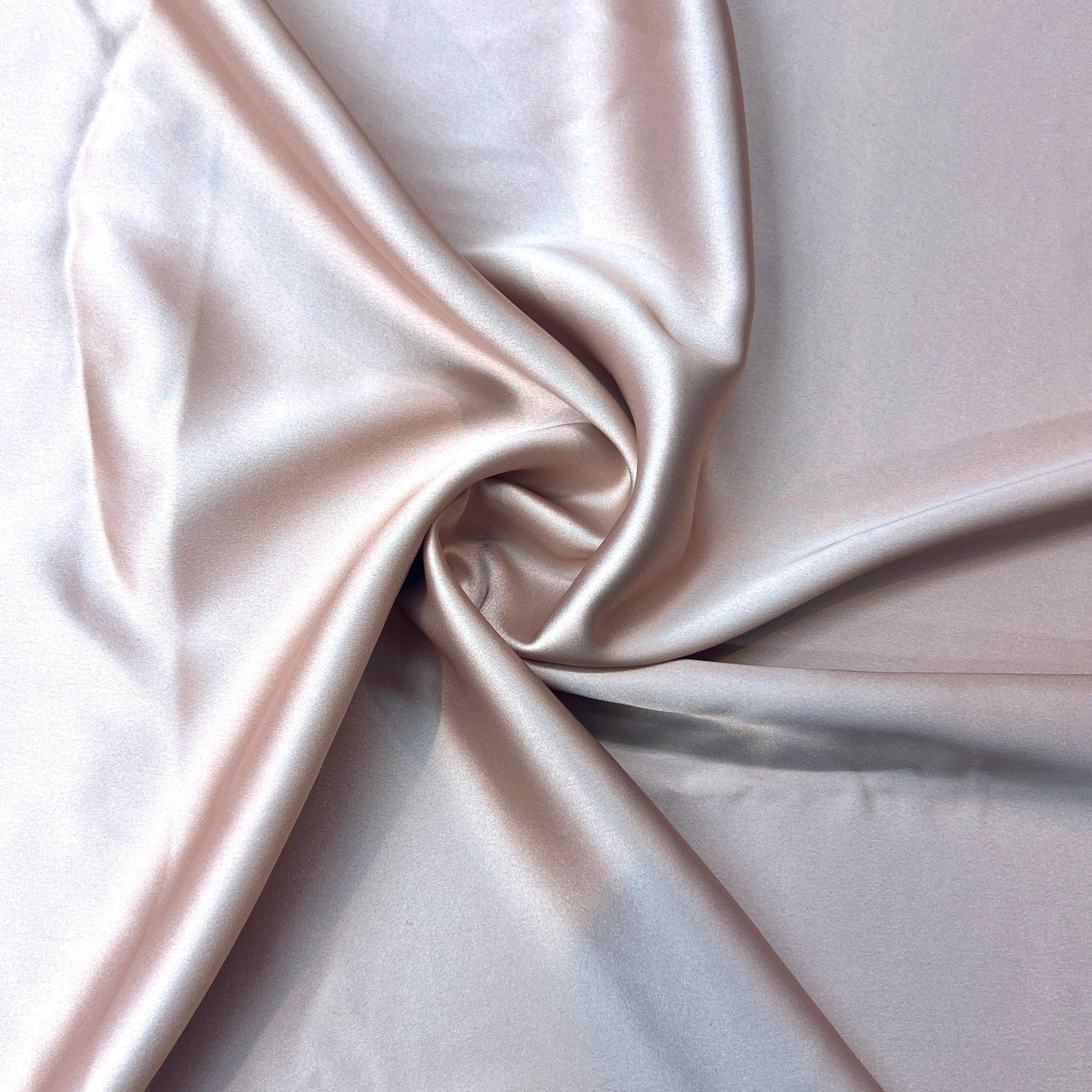 Close-up of beige satin fabric with folds