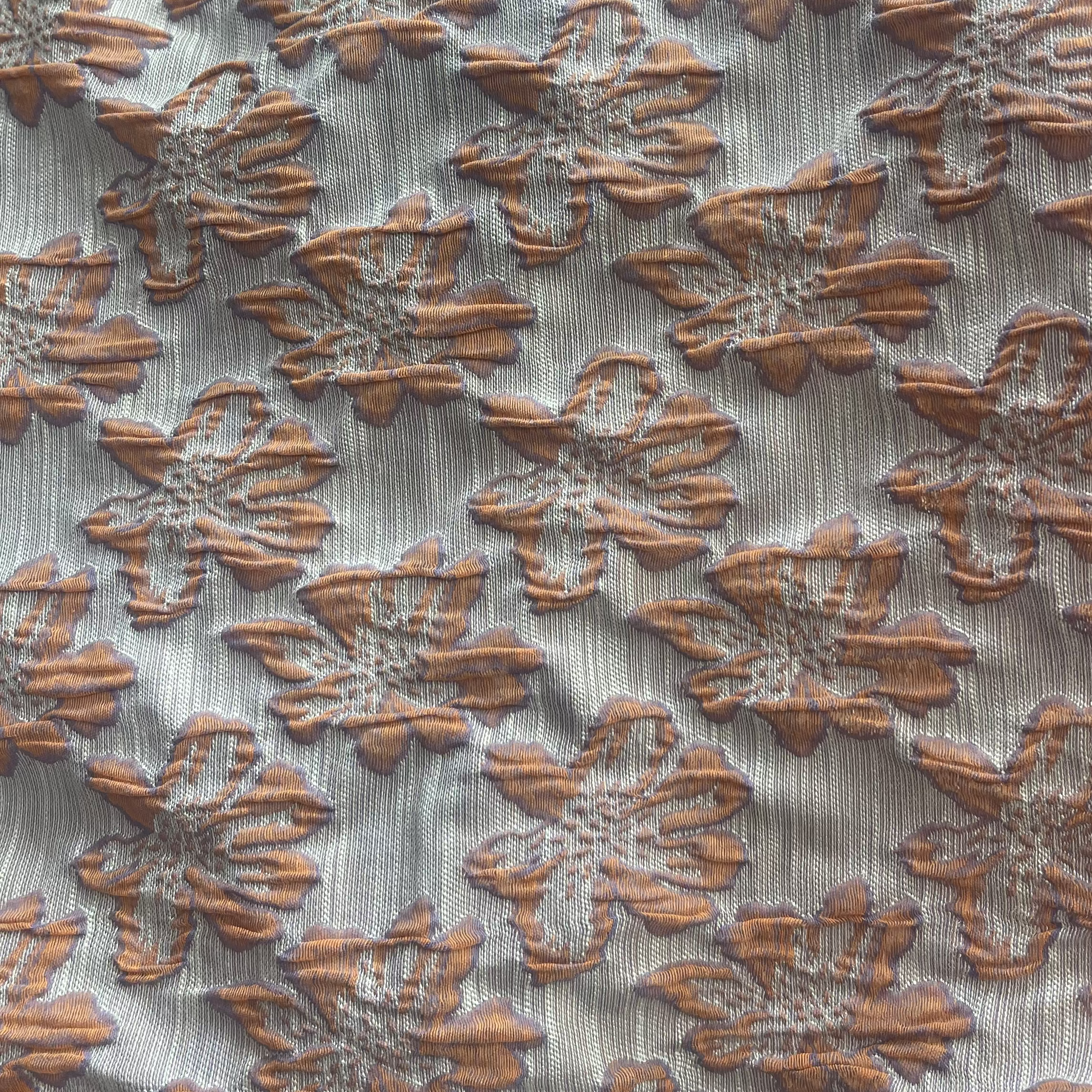 Textured fabric with floral pattern in brown on a light background