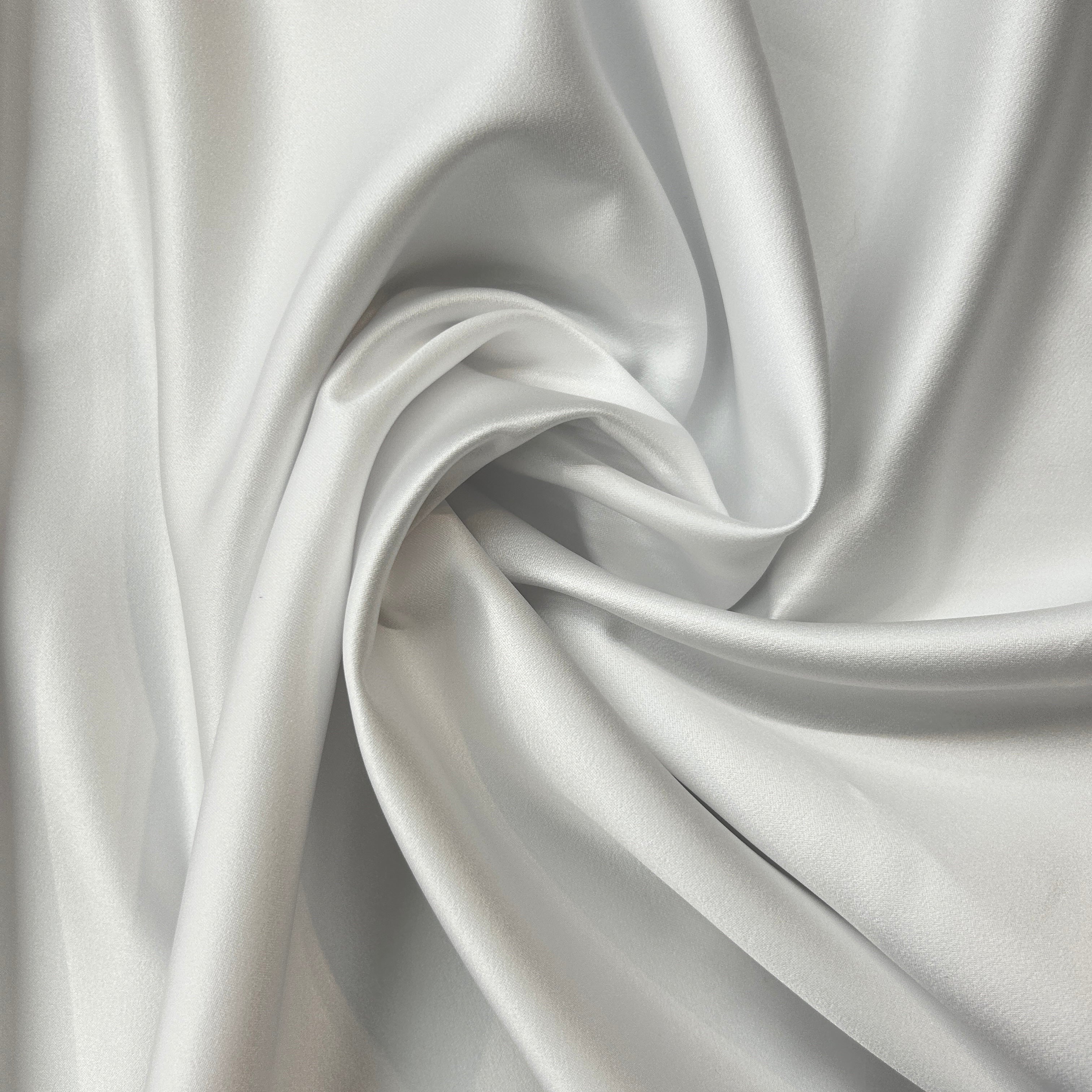 Close-up of silver satin fabric with folds