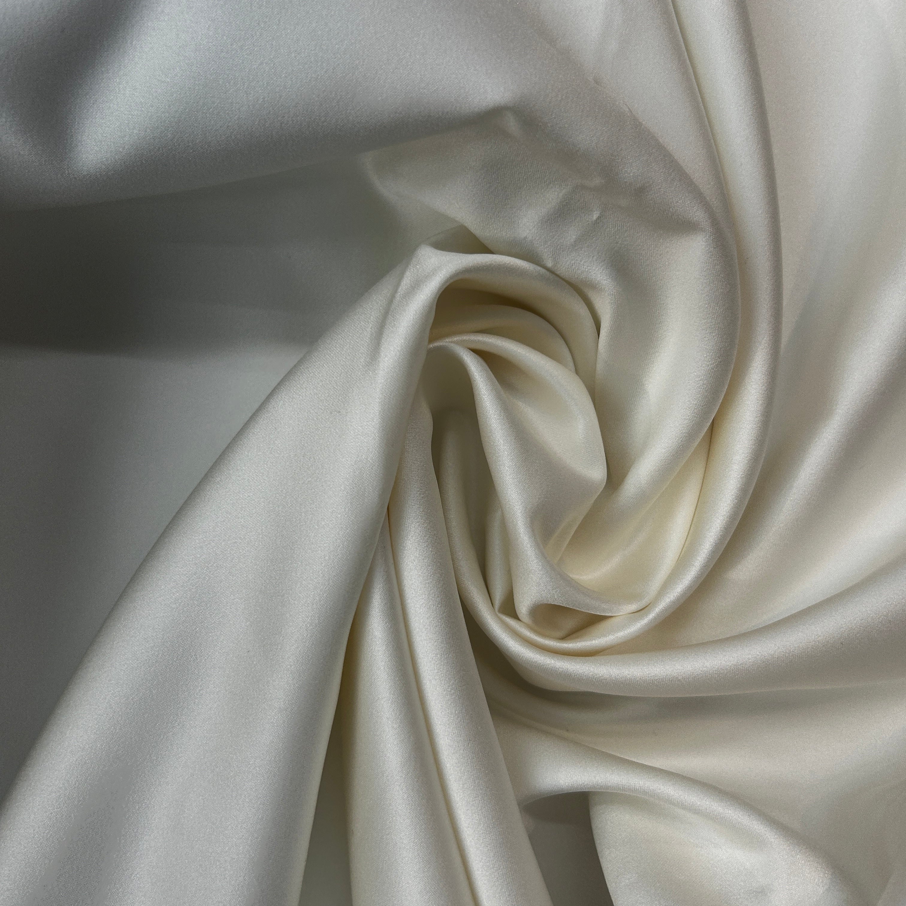 Close-up of smooth, white satin fabric with folds.