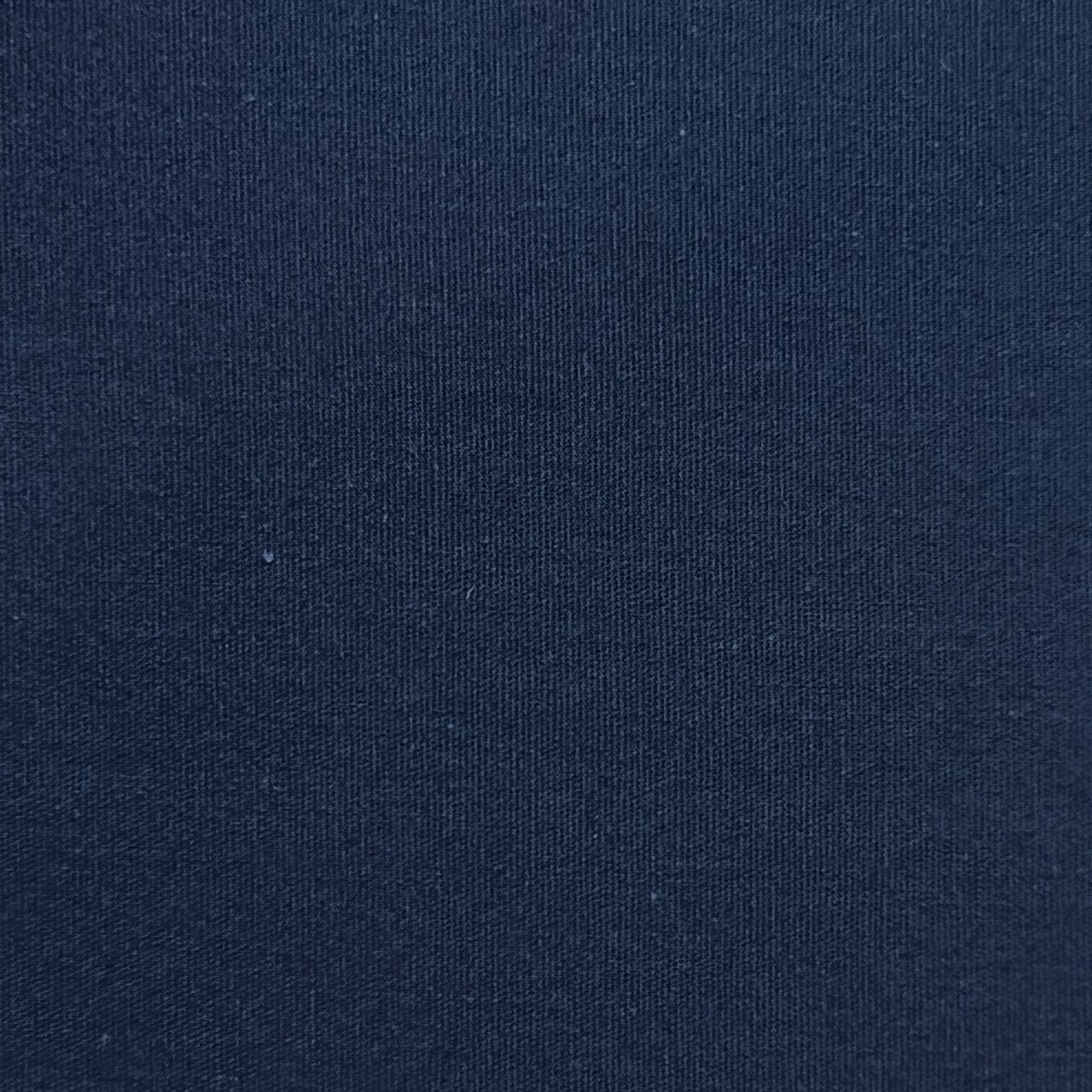 Close-up of navy blue cotton poplin fabric showing its fine, smooth, and tightly woven texture.