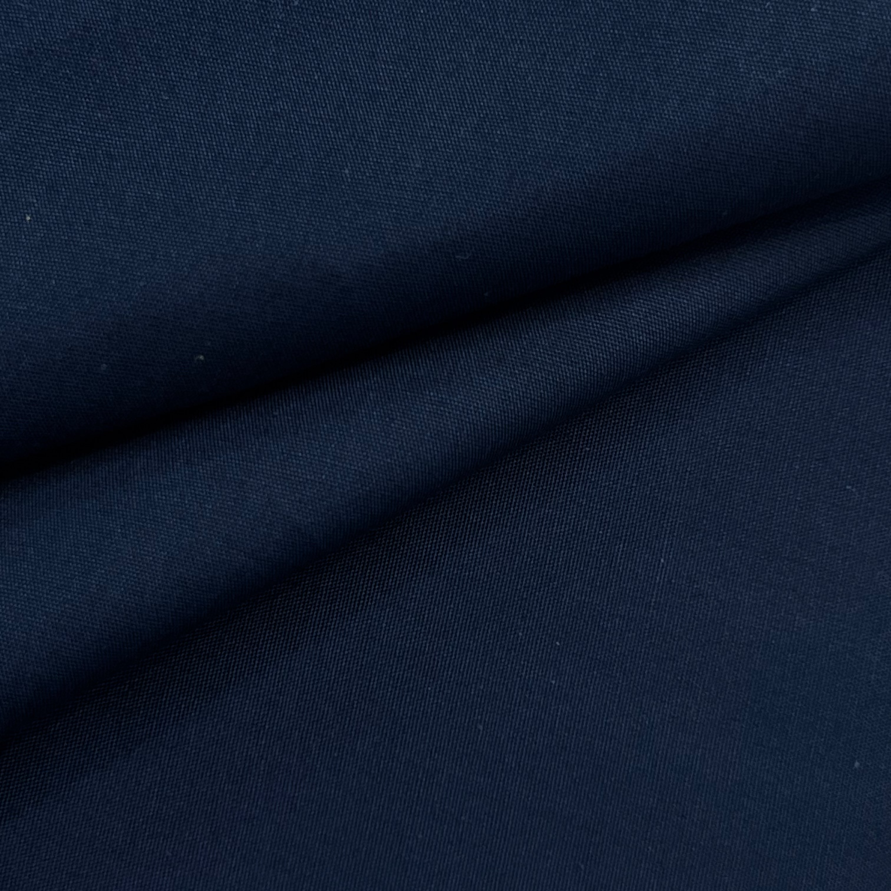 Close-up of navy blue cotton poplin fabric with a smooth, crisp texture and subtle sheen.