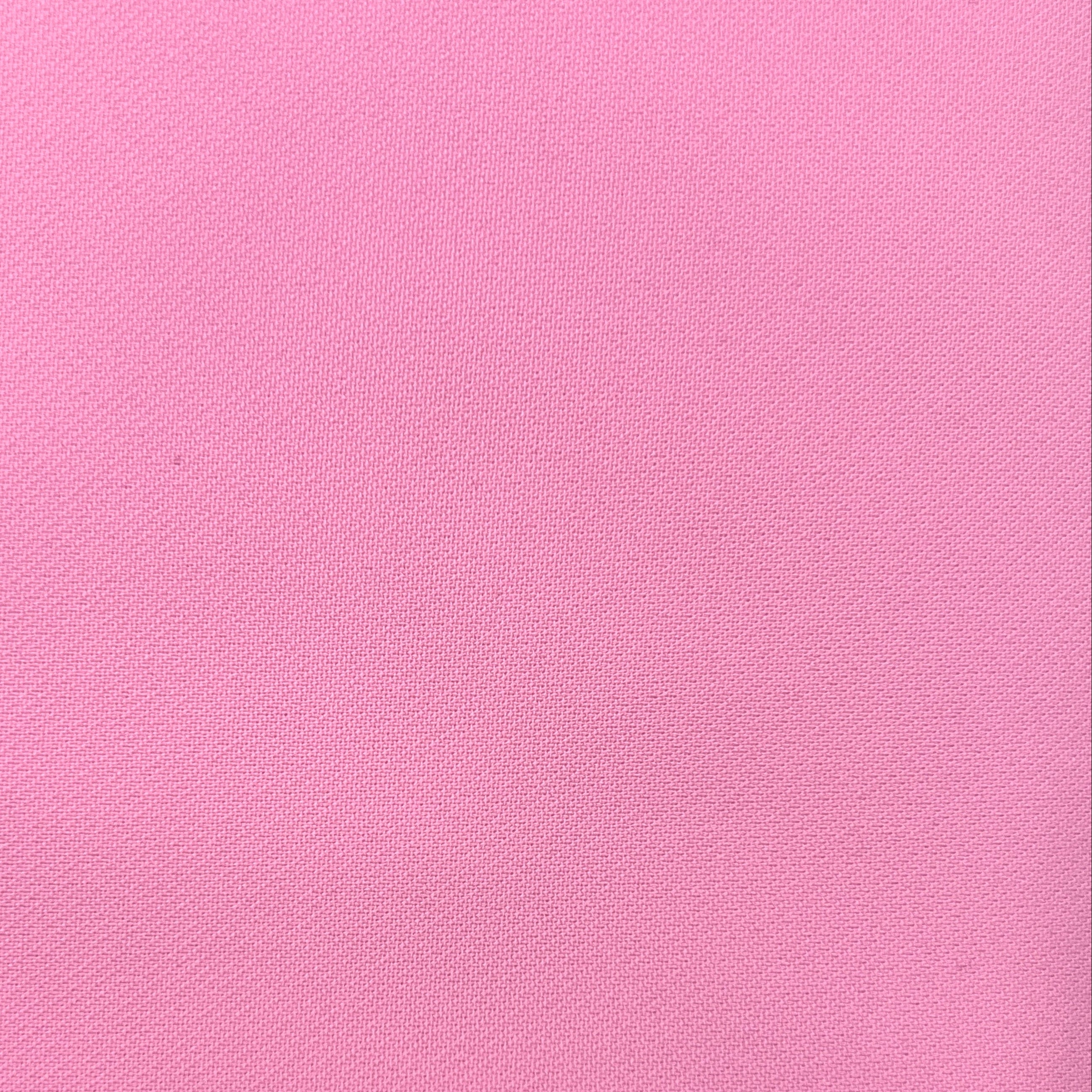 A close-up of a solid pink textured fabric surface.
