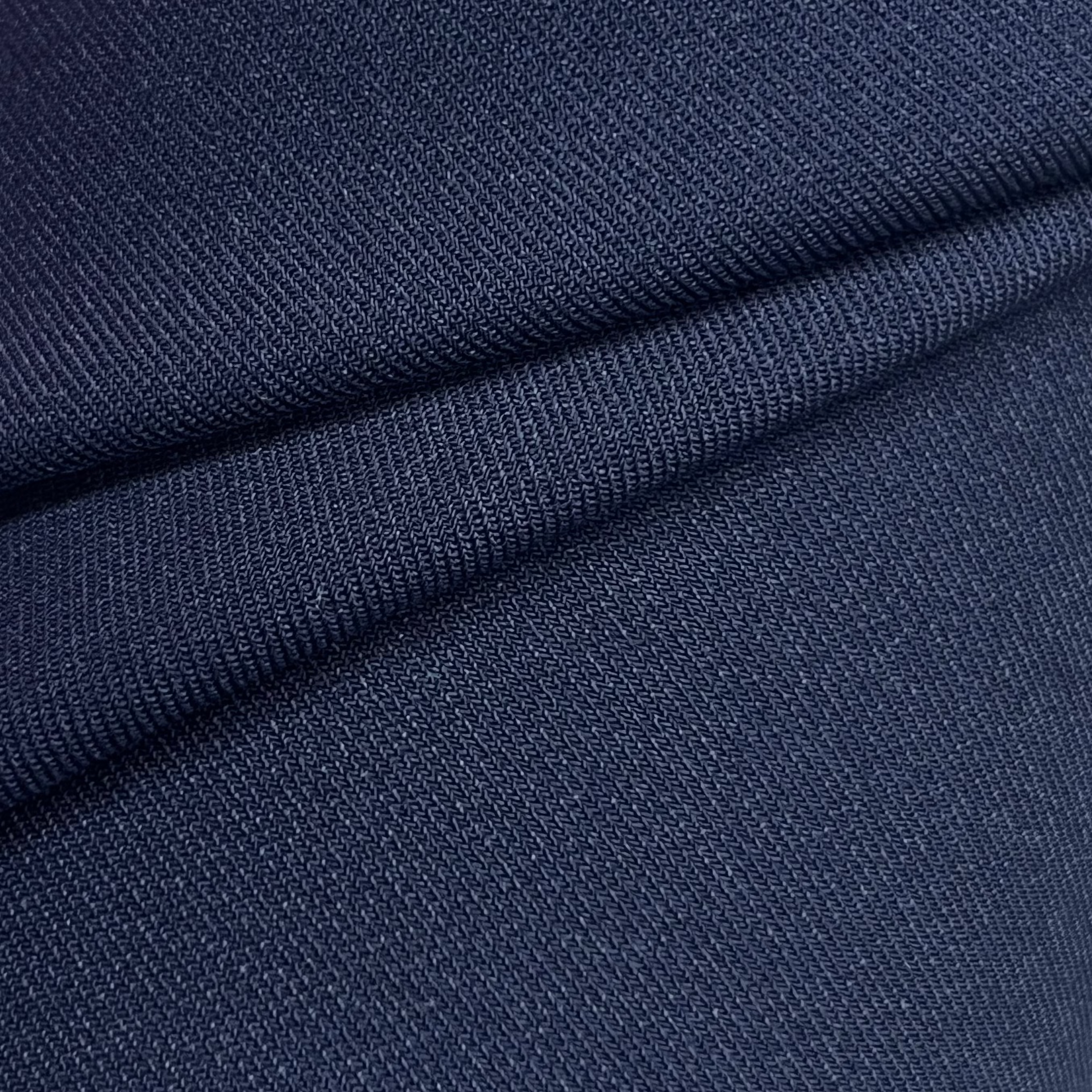 Close-up of navy blue virgin wool and silk suiting fabric with a fine diagonal twill weave.