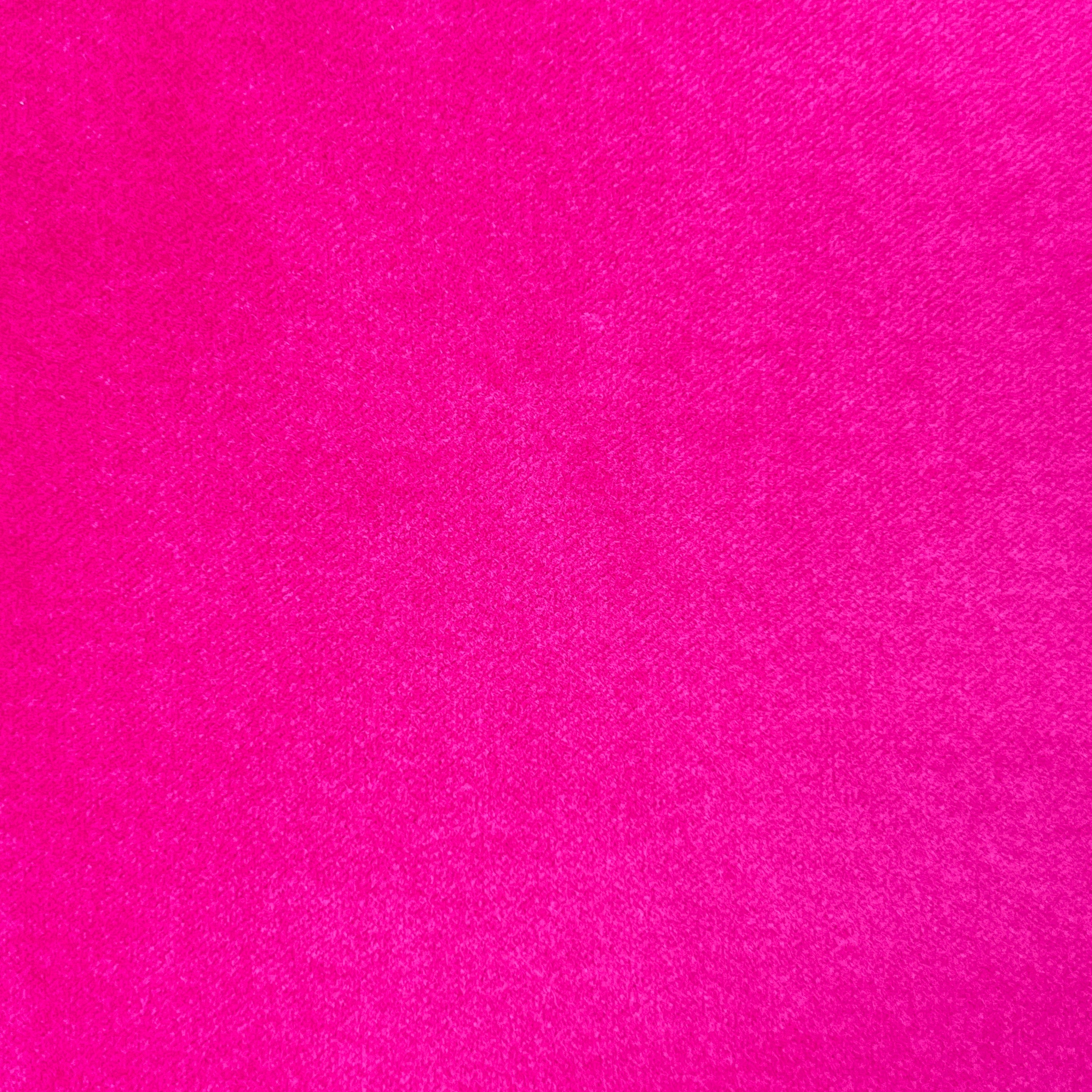 A close-up of bright hot pink fabric with a subtle diagonal twill texture.