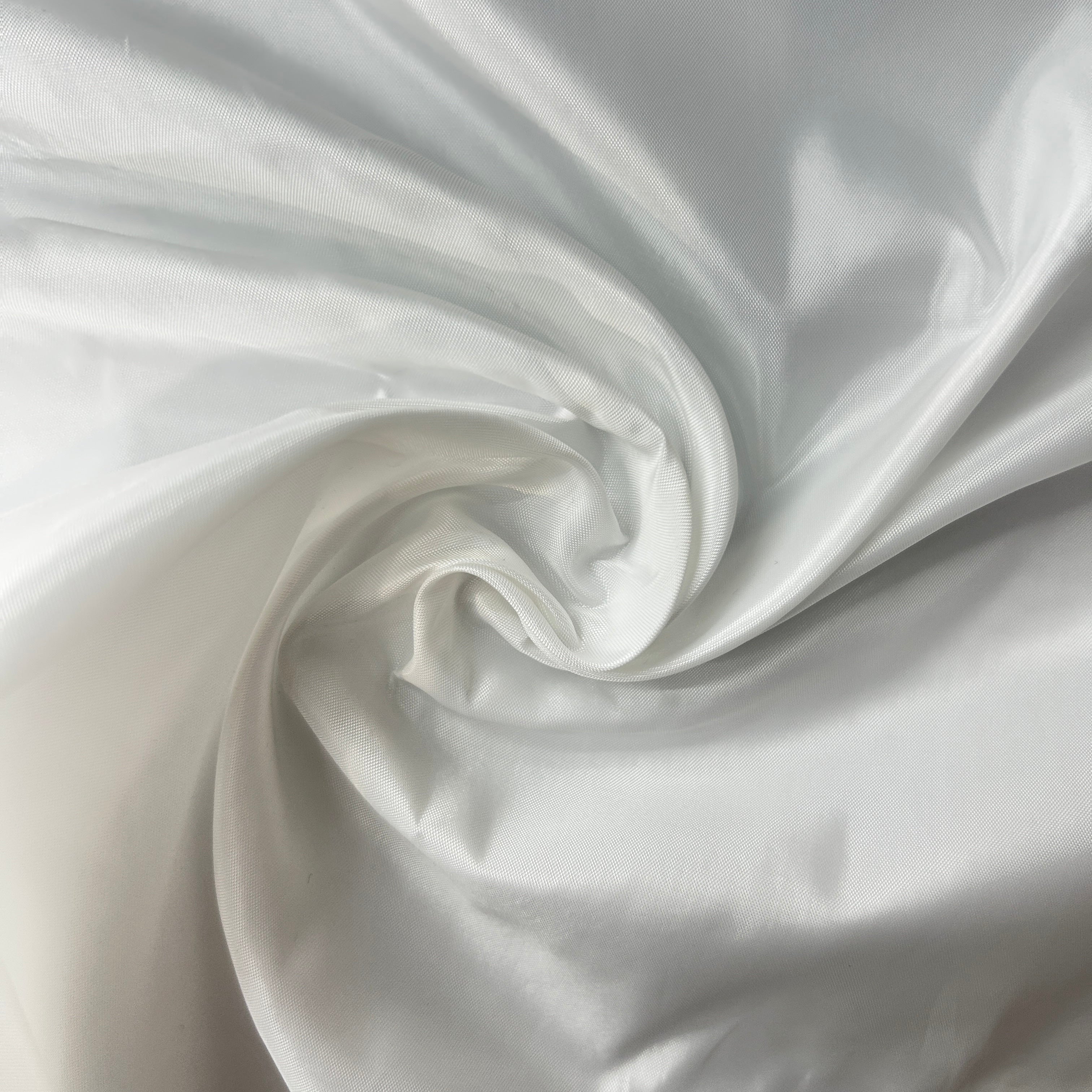 Close-up of white satin fabric with folds