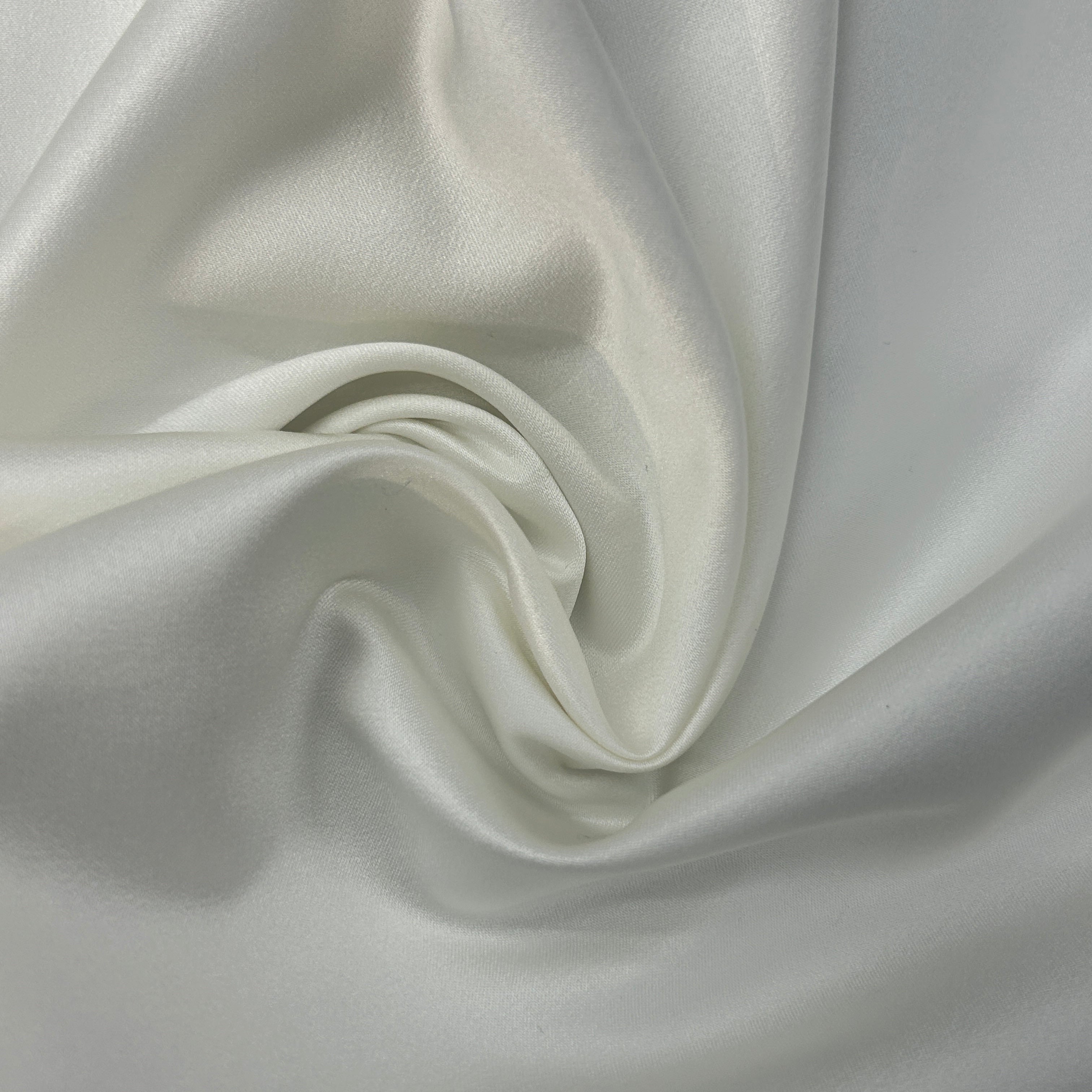 Close-up of white satin fabric with folds