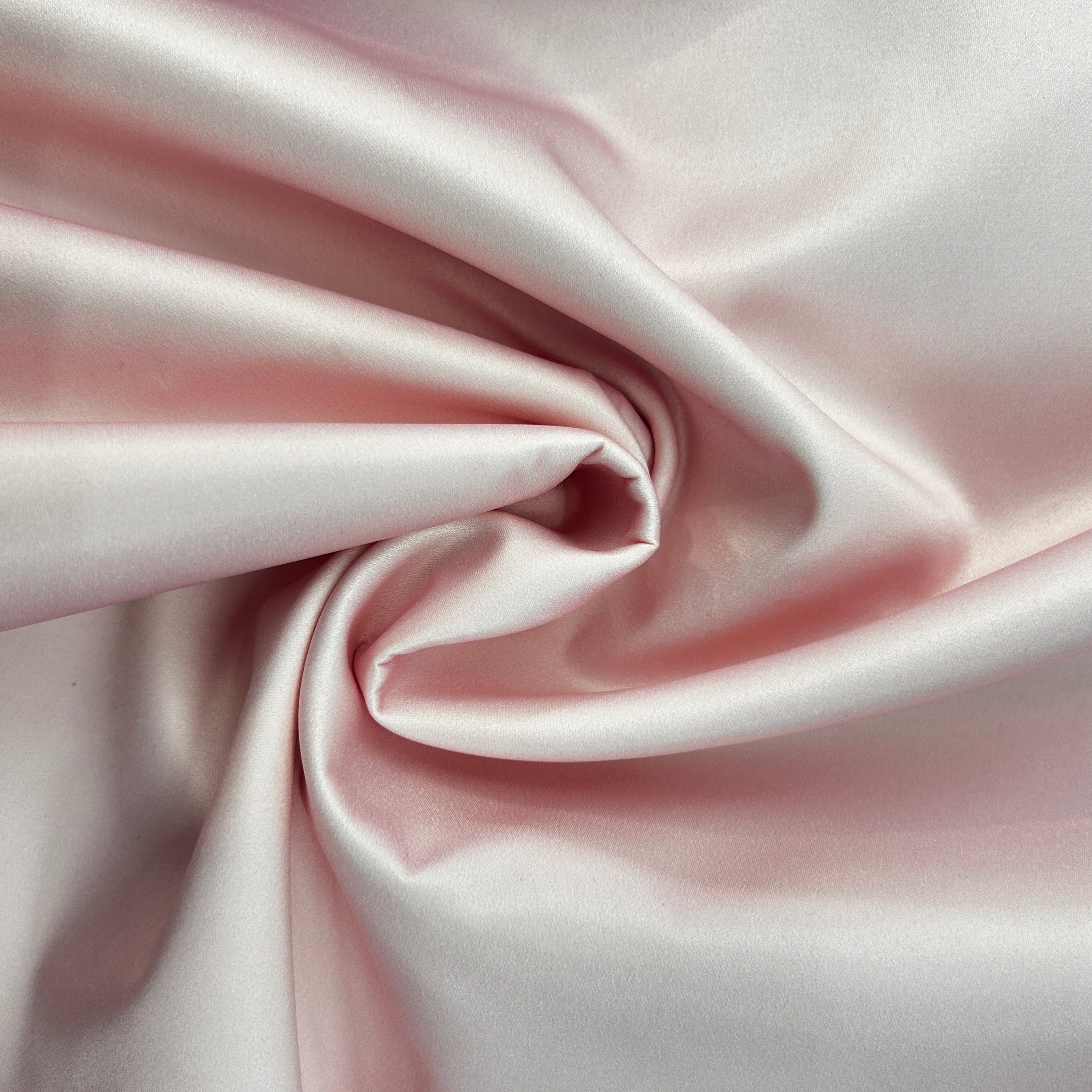 Close-up of pink satin fabric with folds