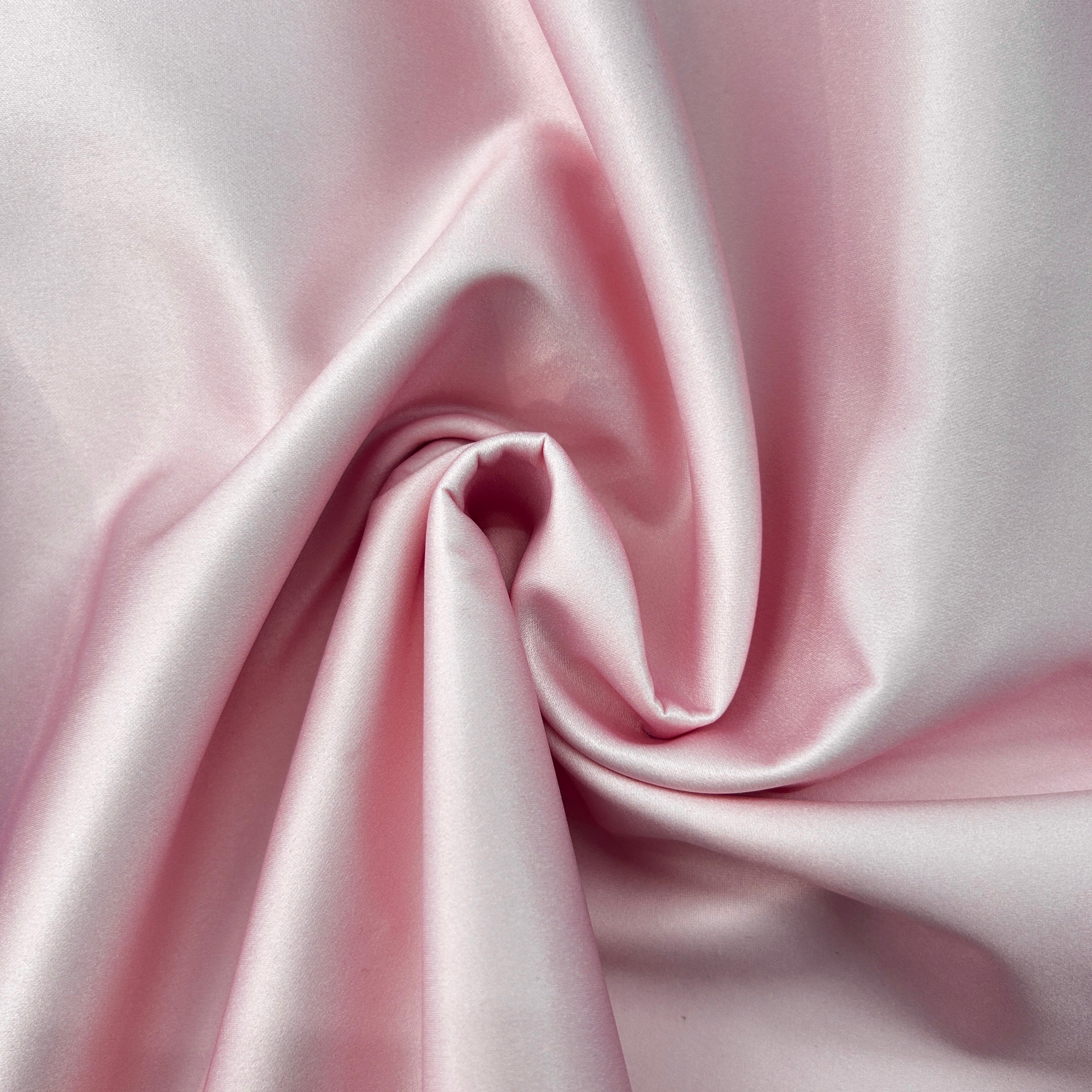 Close-up of pink satin fabric with folds