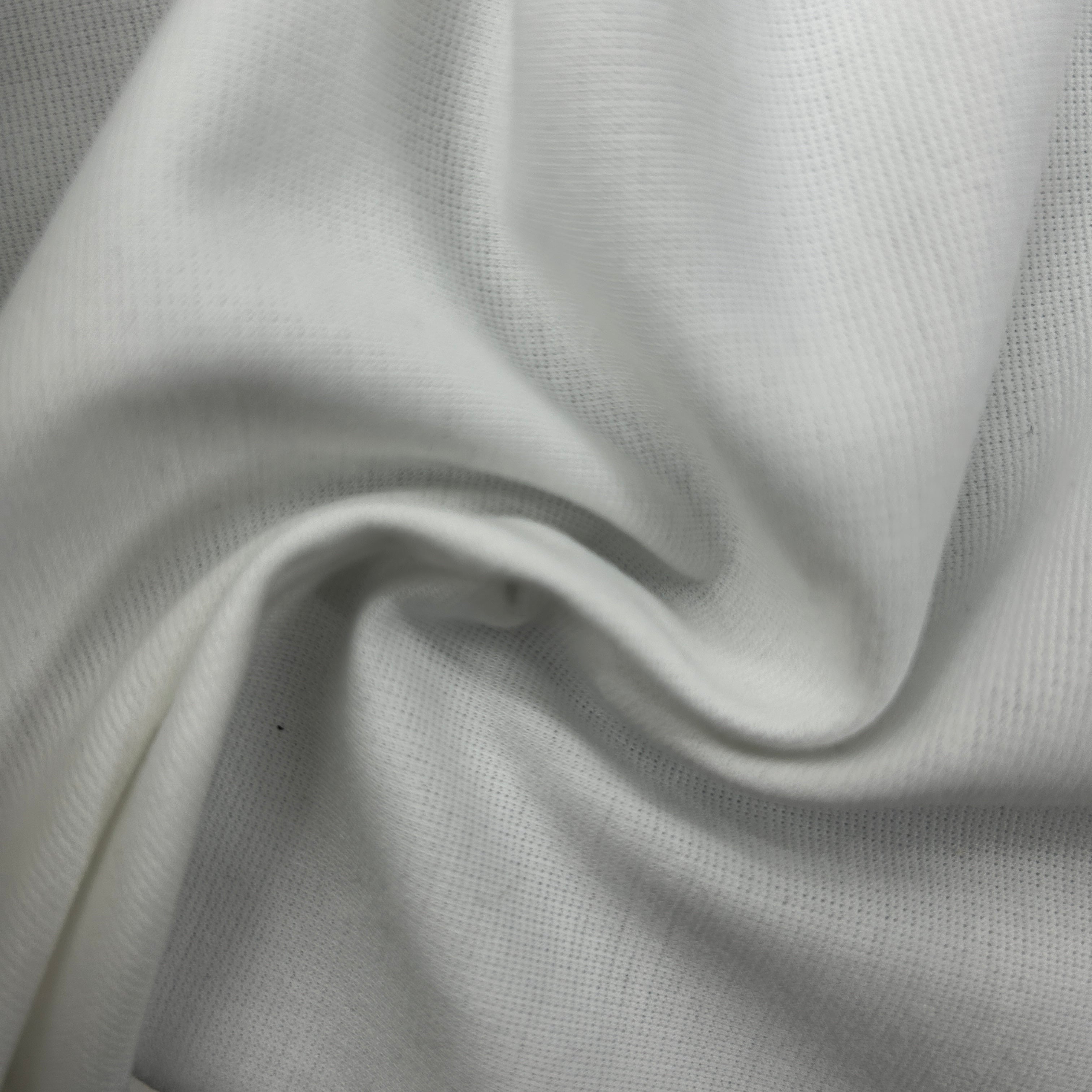 A close-up of draped white fabric with a fine ribbed or woven texture, showing soft folds and shadows.