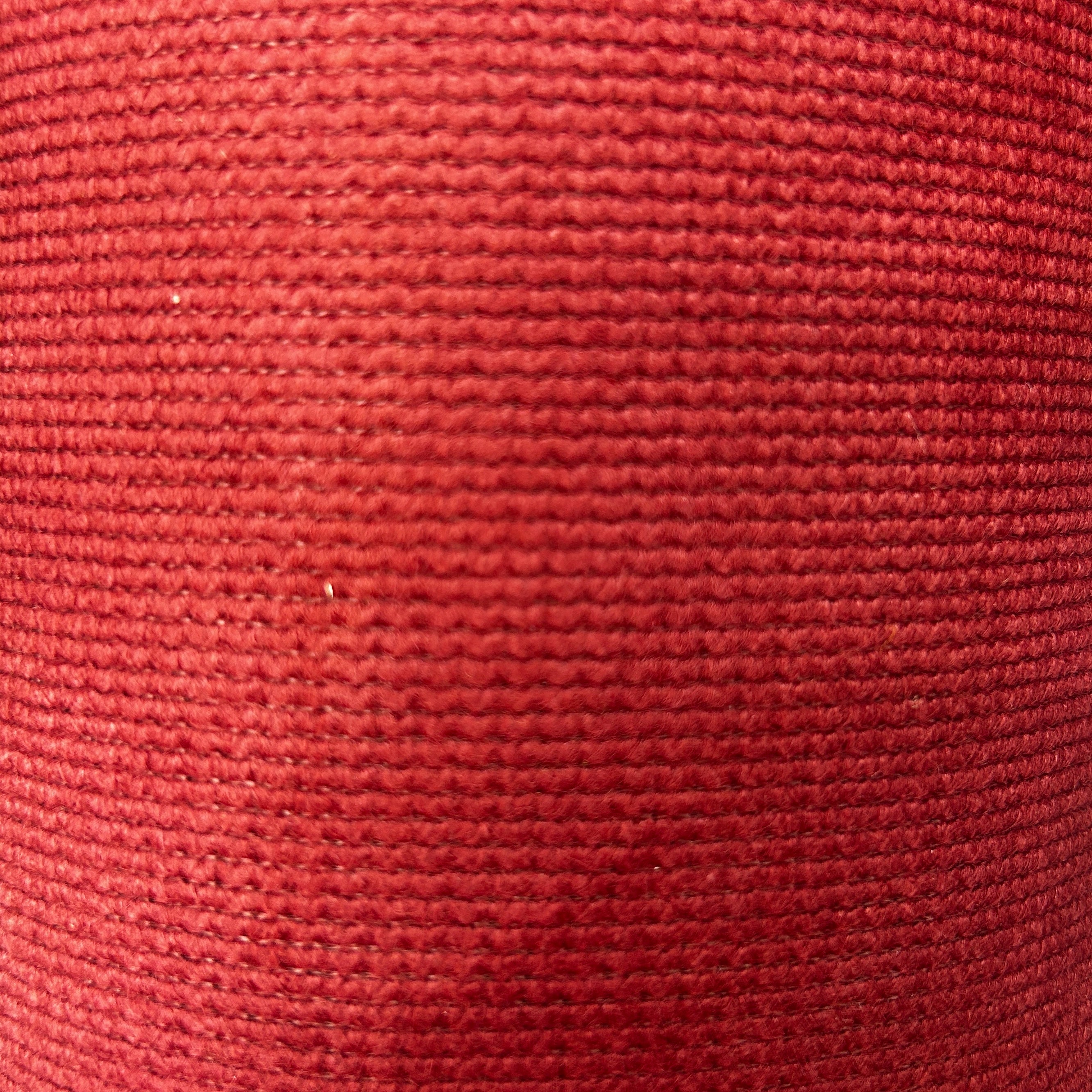 Close-up of red and green thick interfacing knit apparel fabric with a textured ribbed pattern.