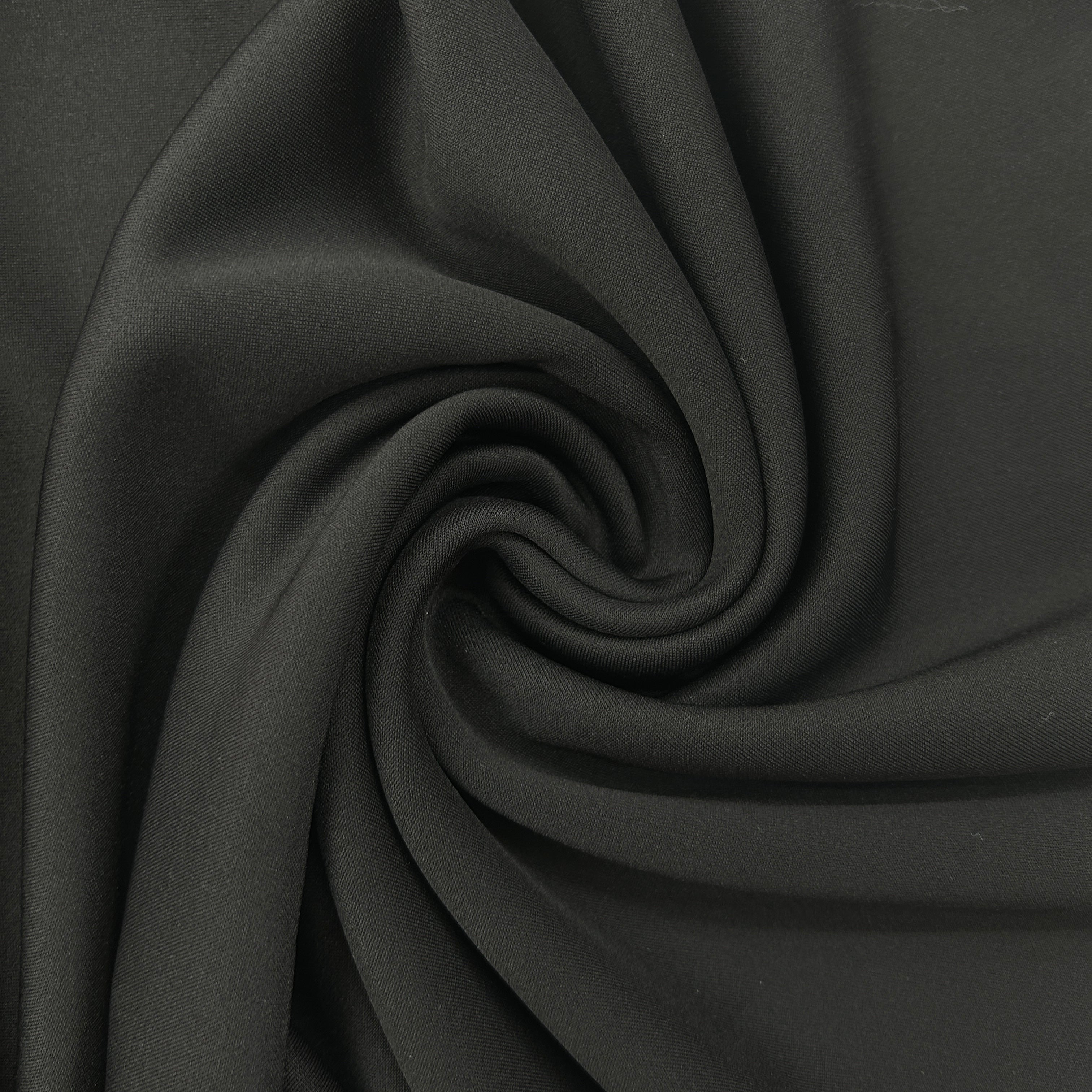 A close-up of dark charcoal gray fabric arranged in a spiral drape, showing its smooth texture and soft folds.