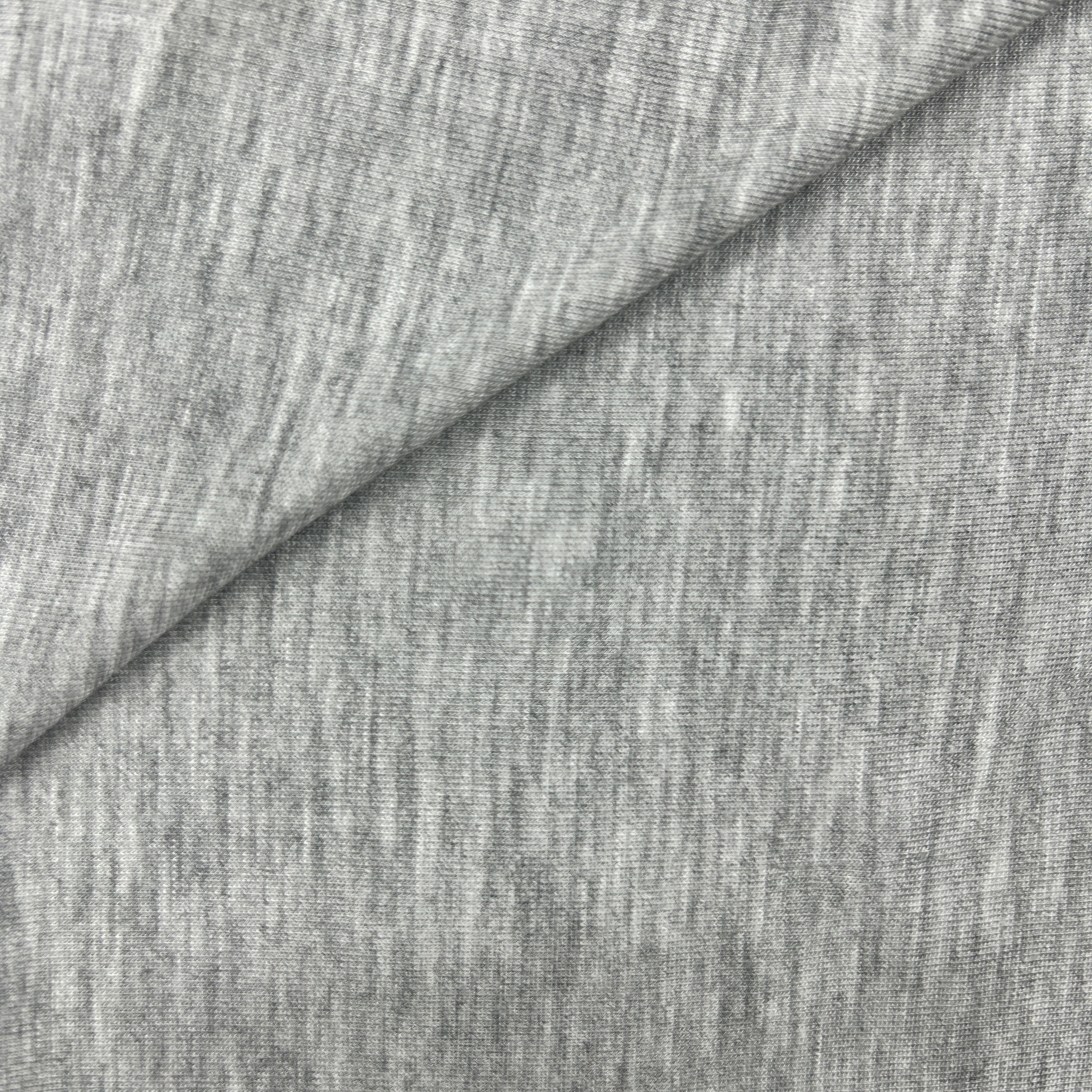 Close-up of a heather gray fabric texture with a diagonal fold showing the material's fine knit pattern.