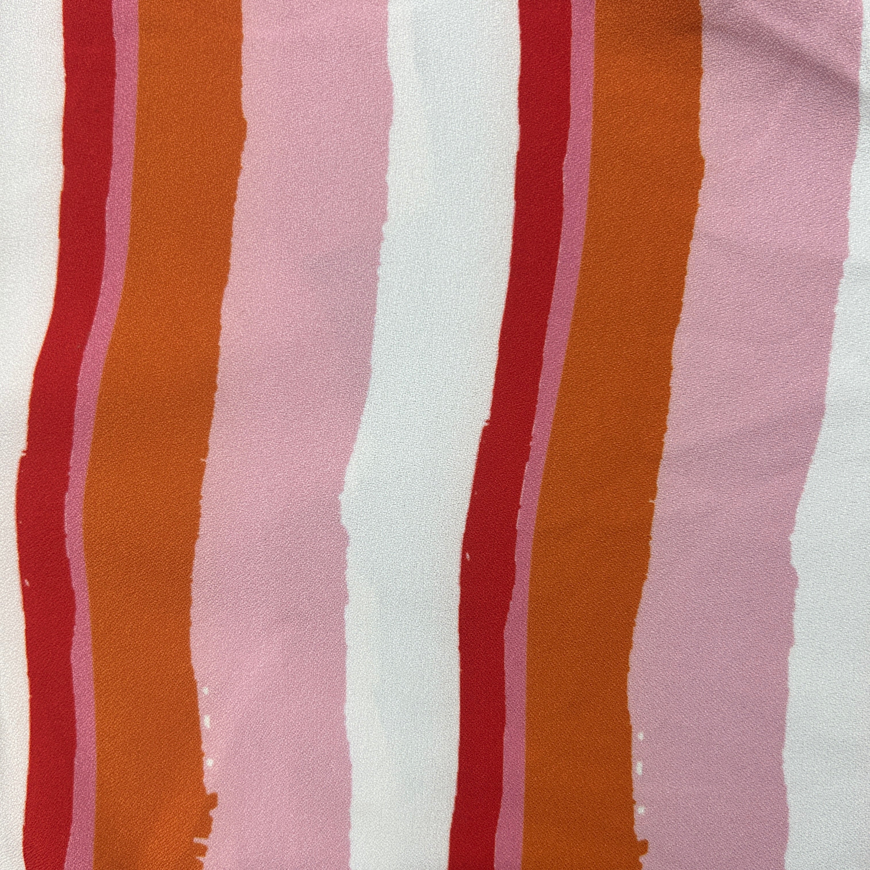 A close-up of a striped fabric pattern featuring vertical bands of rust orange, deep red, dusty pink, and white with a textured, slightly wrinkled finish.
