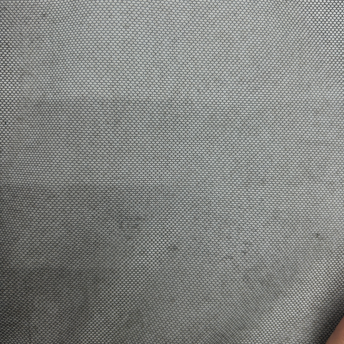 Close-up of lightweight black polyester tulle mesh fabric with a fine open grid-like structure.