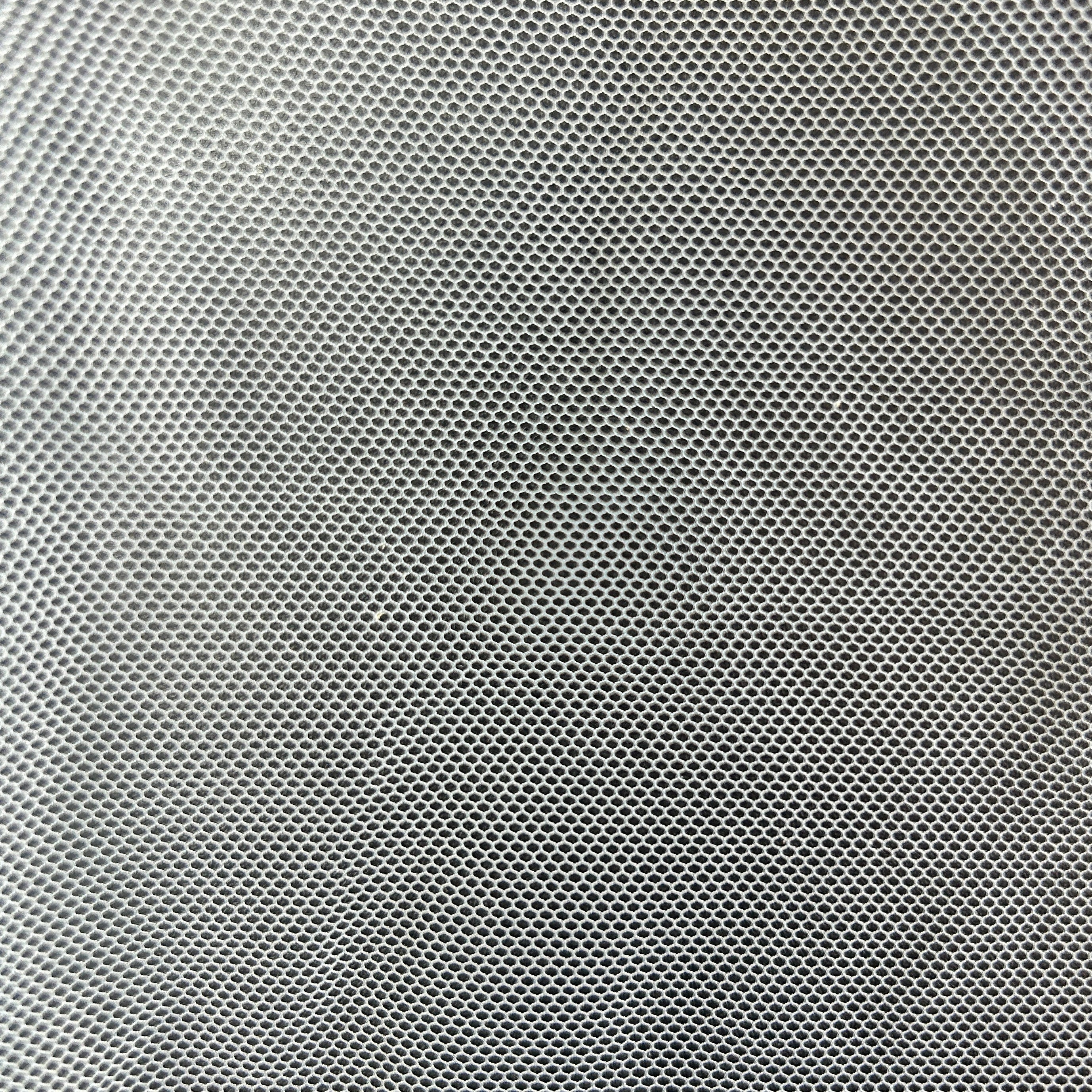 Close-up of lightweight white polyester tulle fabric with a fine open mesh structure.