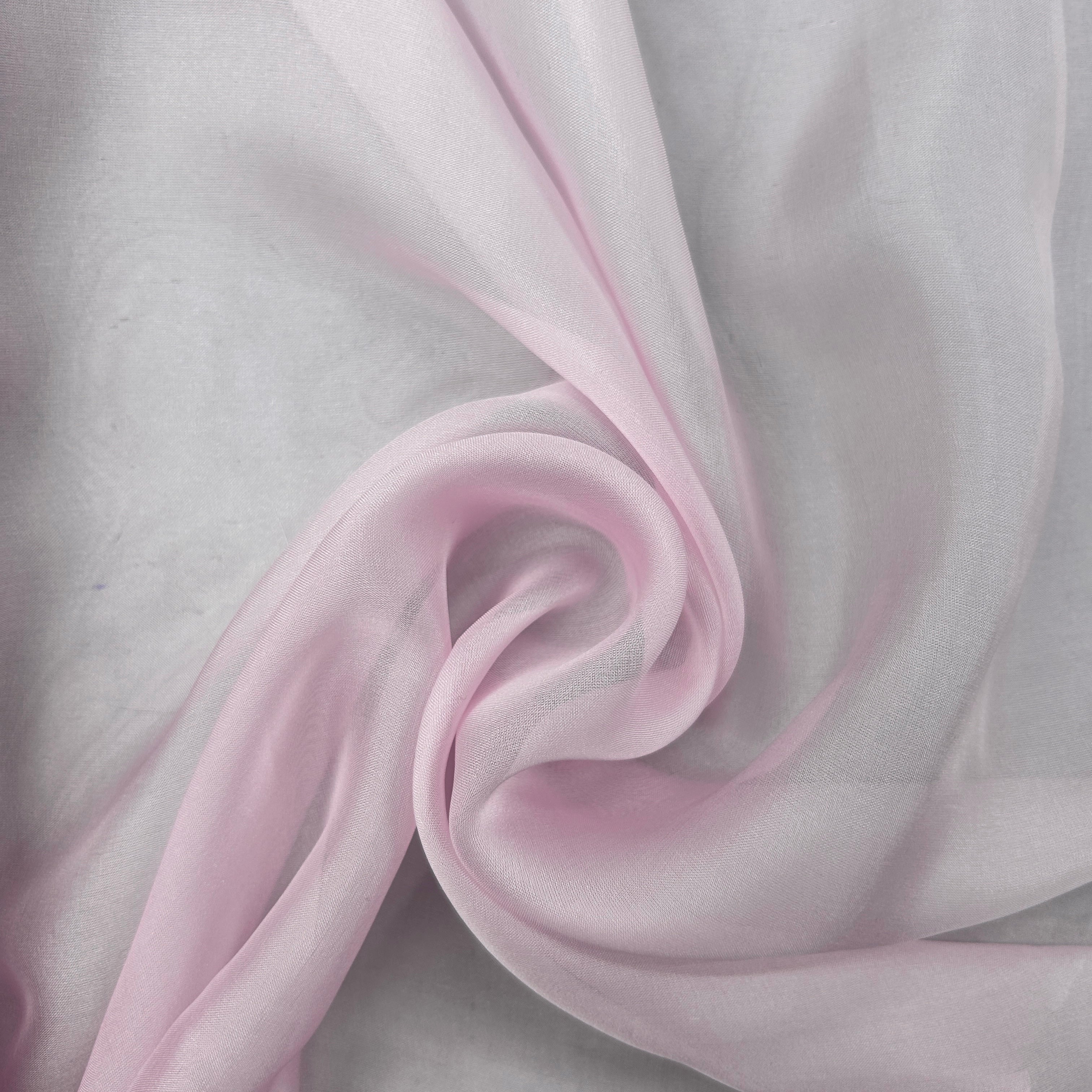 Light pink sheer organza fabric draped in elegant swirls over a light gray background.
