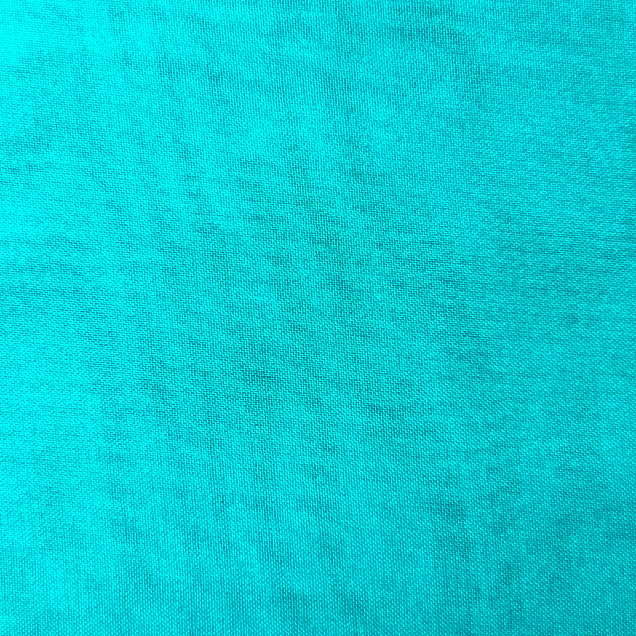 A close-up view of a vibrant turquoise polyester chiffon fabric with a fine, matte texture.