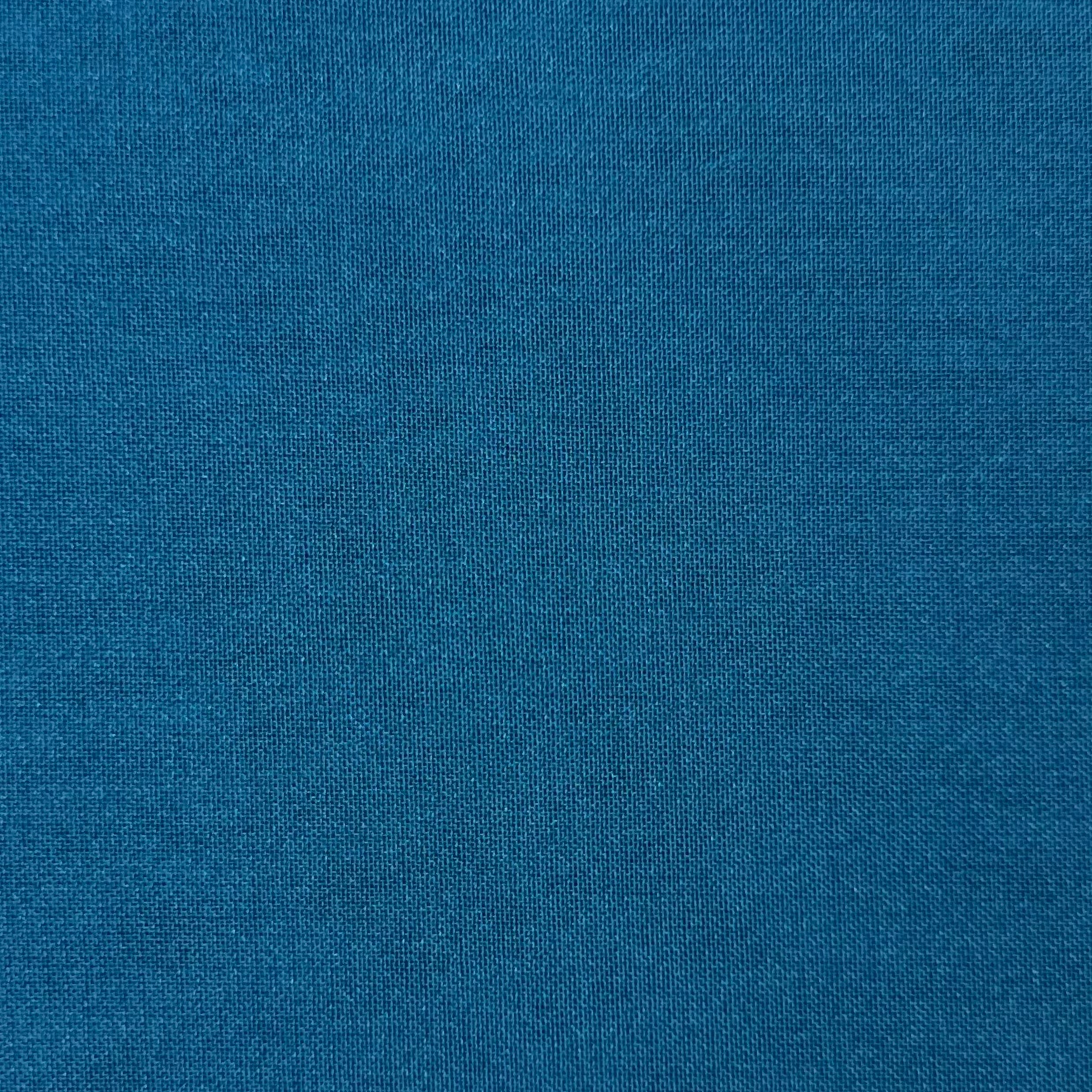 A close-up view of a solid teal blue polyester chiffon fabric with a fine, matte texture.