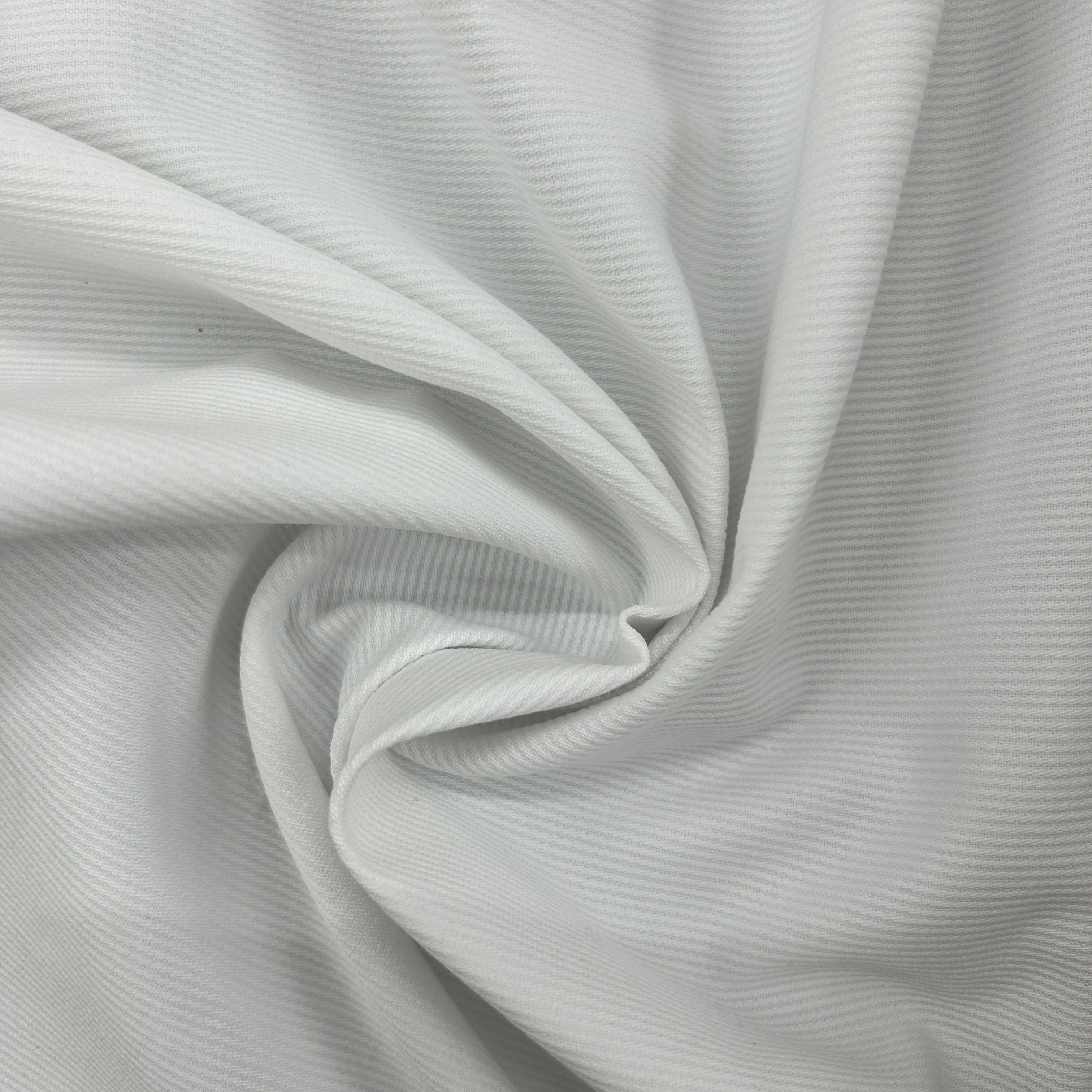 A close-up of light gray ribbed fabric with soft folds and a textured surface.