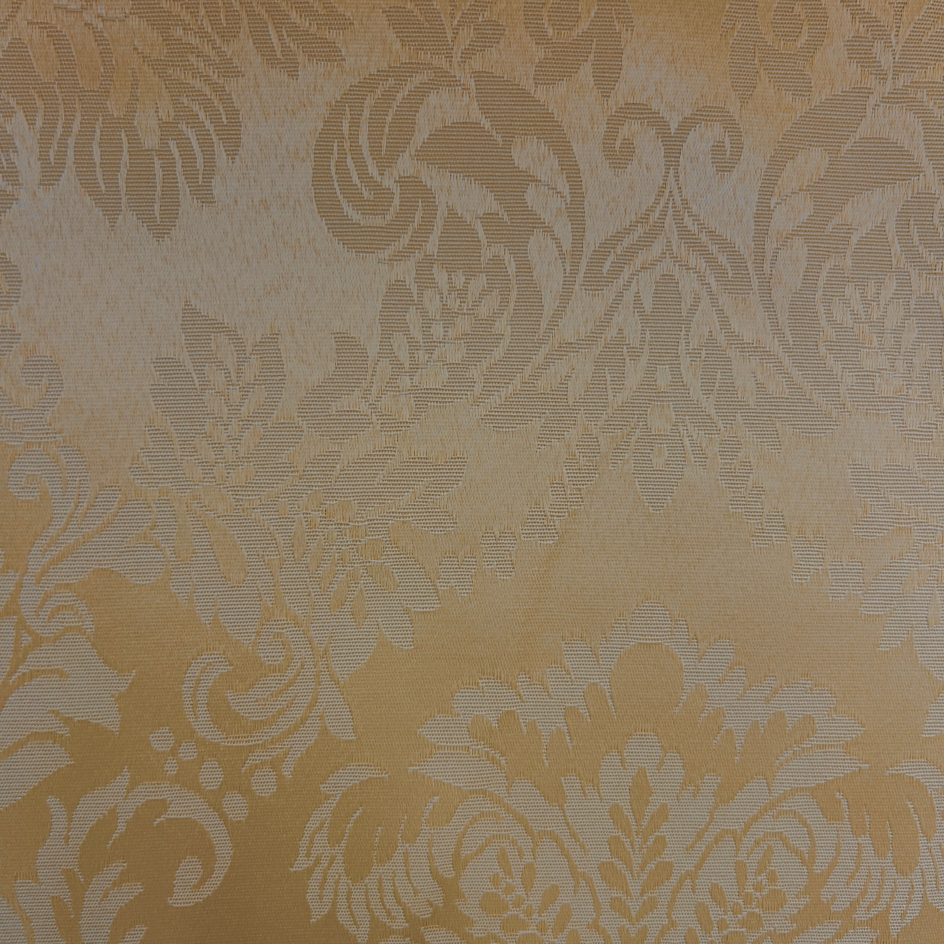 A close-up of a damask fabric texture with a warm beige and light brown floral pattern.