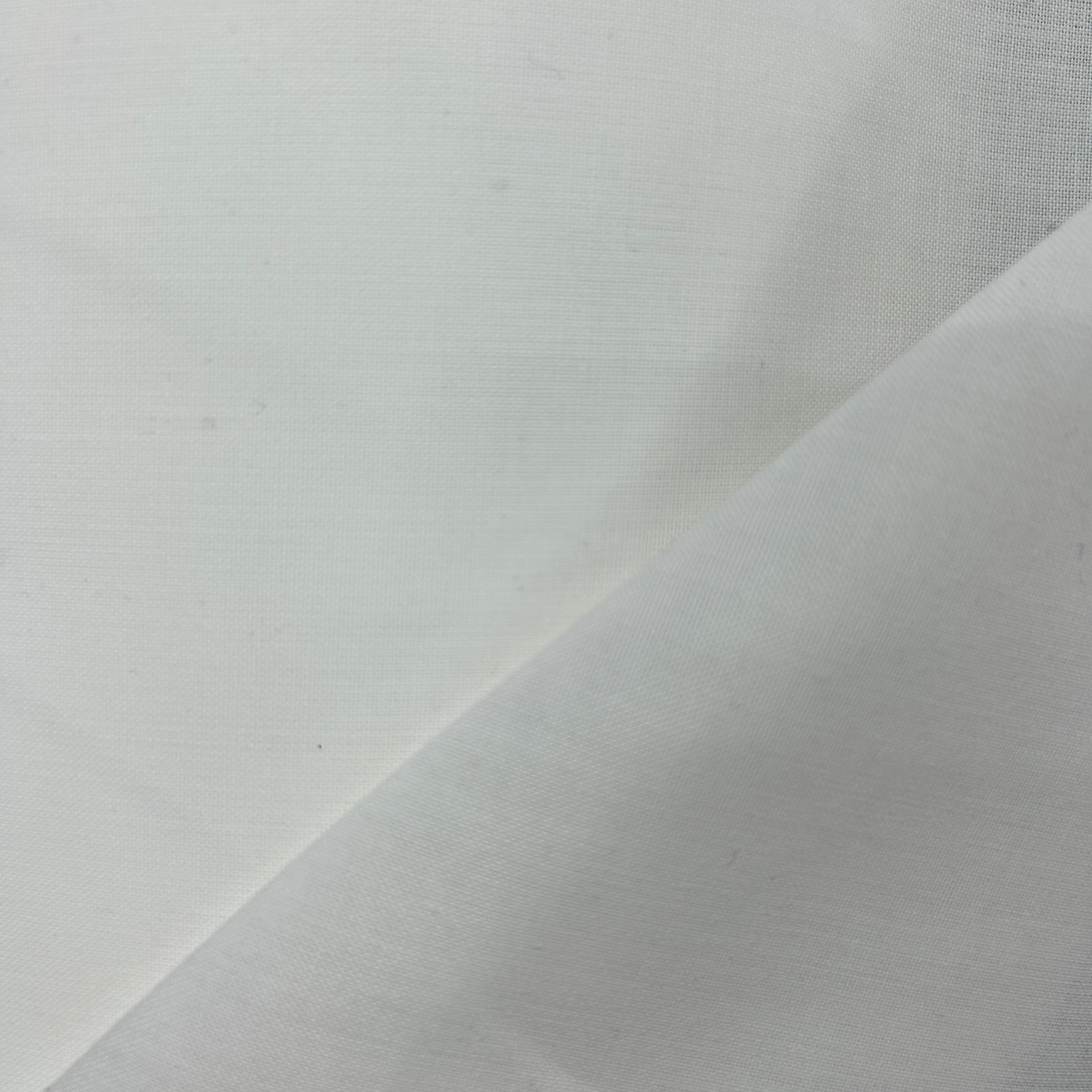 A close-up of plain white fabric with a visible woven texture and a diagonal fold.