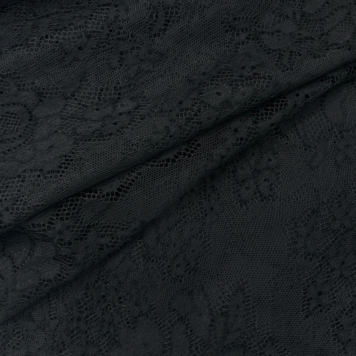 Close-up of dark charcoal gray lace fabric with a floral pattern and semi-sheer texture, draped in soft folds.