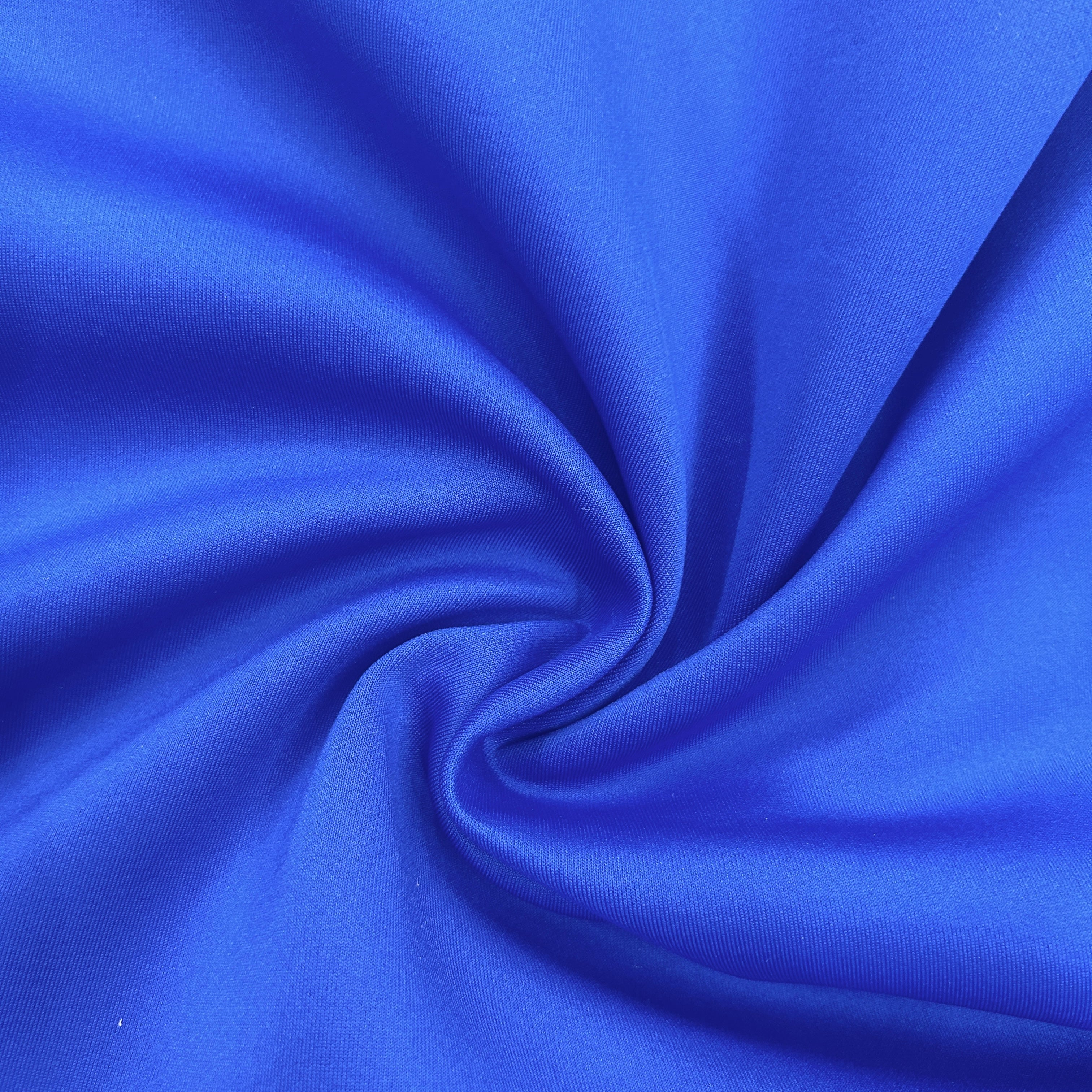 A close-up of bright royal blue fabric arranged in a spiral drape, showing the material texture and sheen.