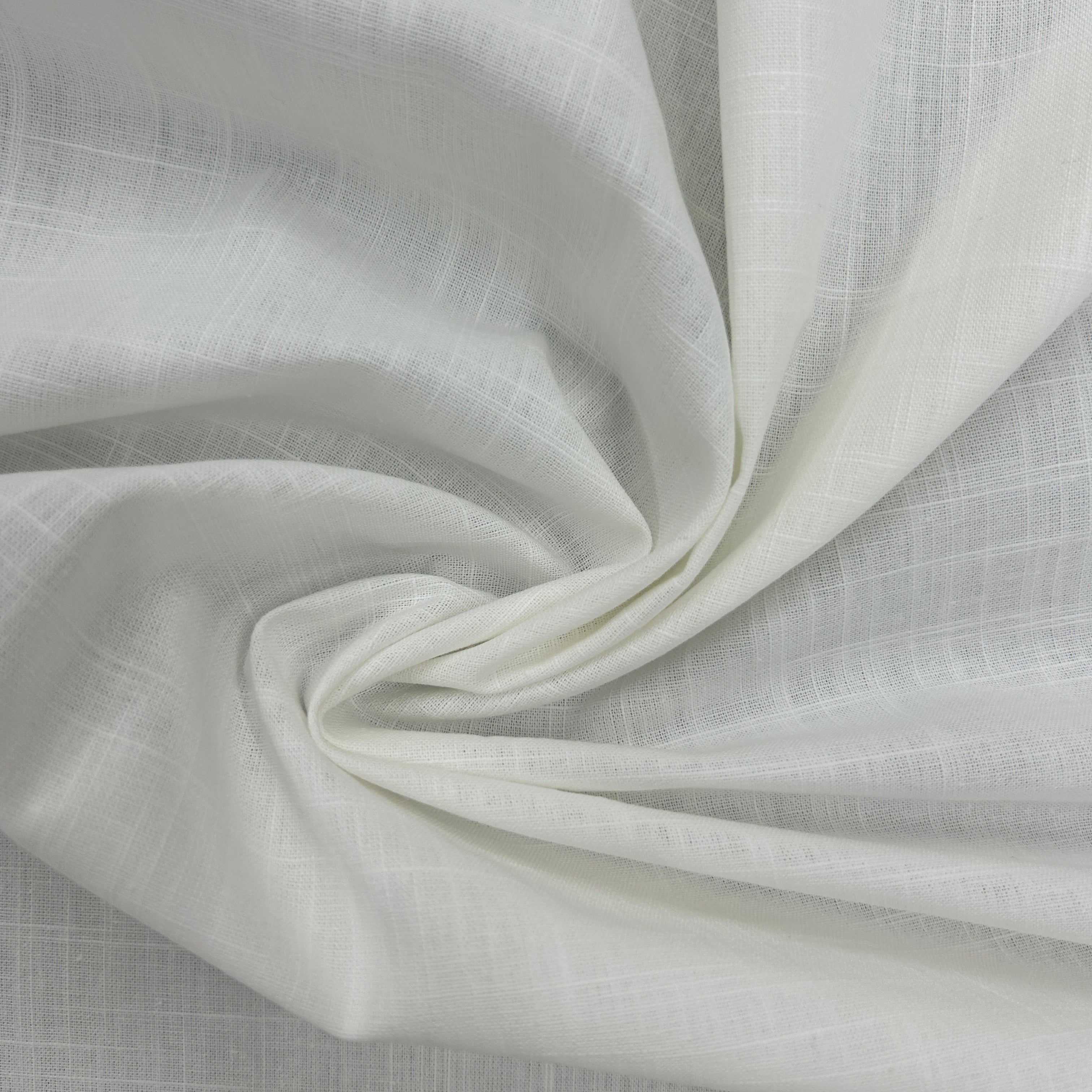 A close-up of draped off-white fabric with a subtle woven texture, arranged in soft folds.