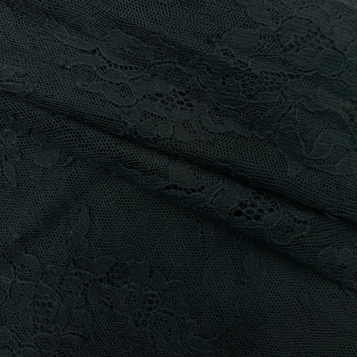 Close-up of a dark lace fabric with floral patterns and openwork mesh texture.