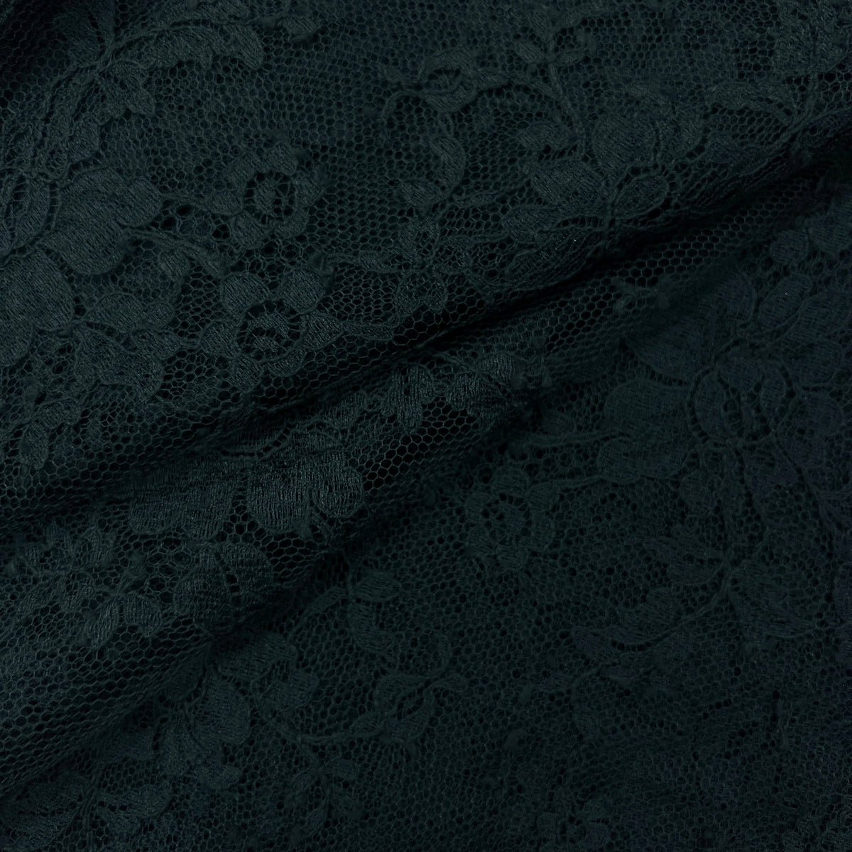 Close-up of dark navy lace fabric with an intricate floral pattern and sheer mesh texture.