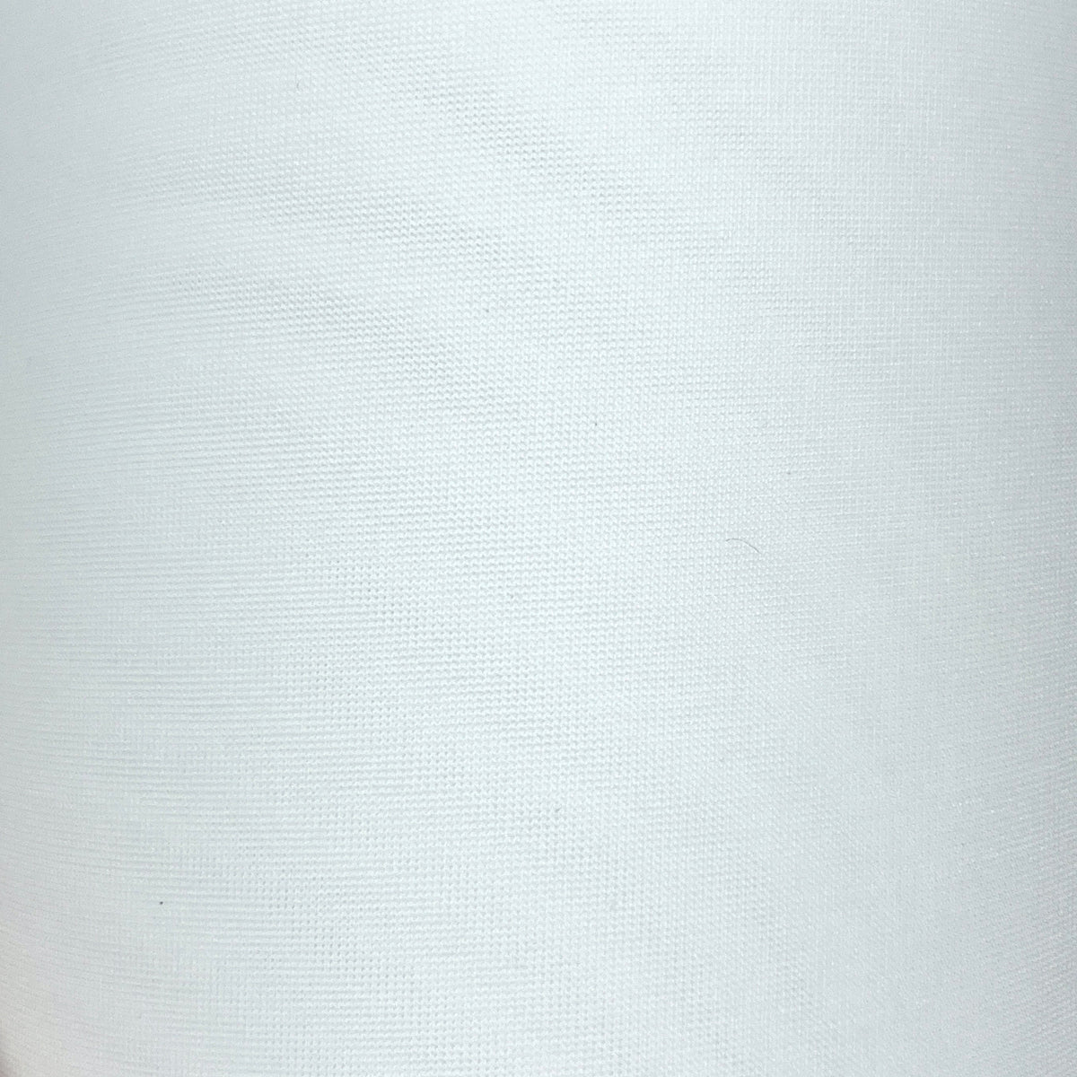 A close-up of a white textured fabric or material roll being held at the bottom by a hand, with a silver ring visible on one finger.