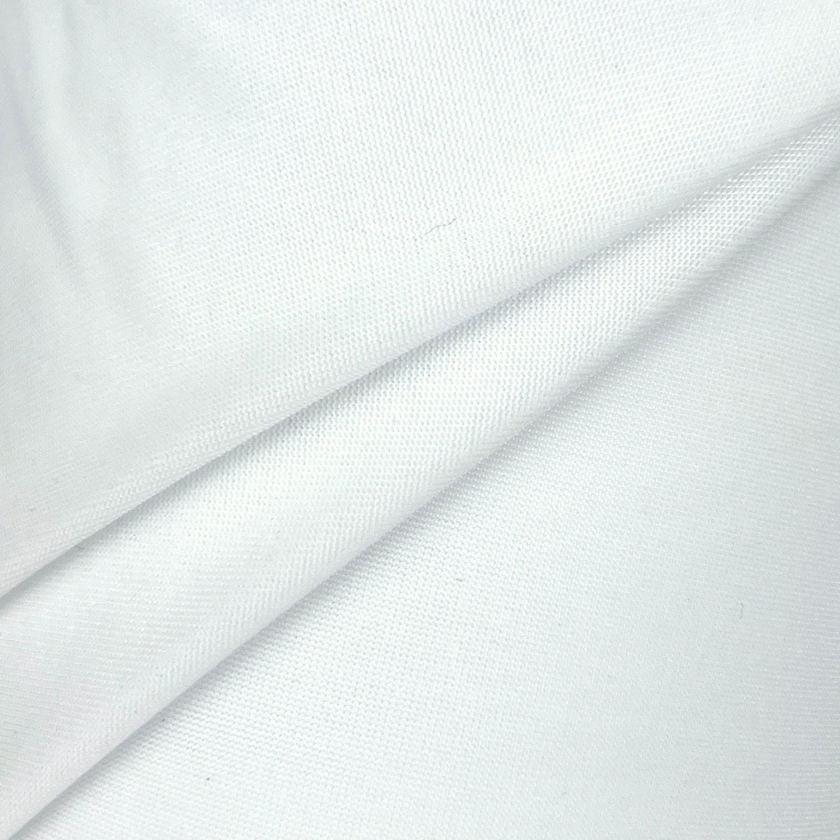 A close-up of white fabric with soft folds and a fine woven texture.