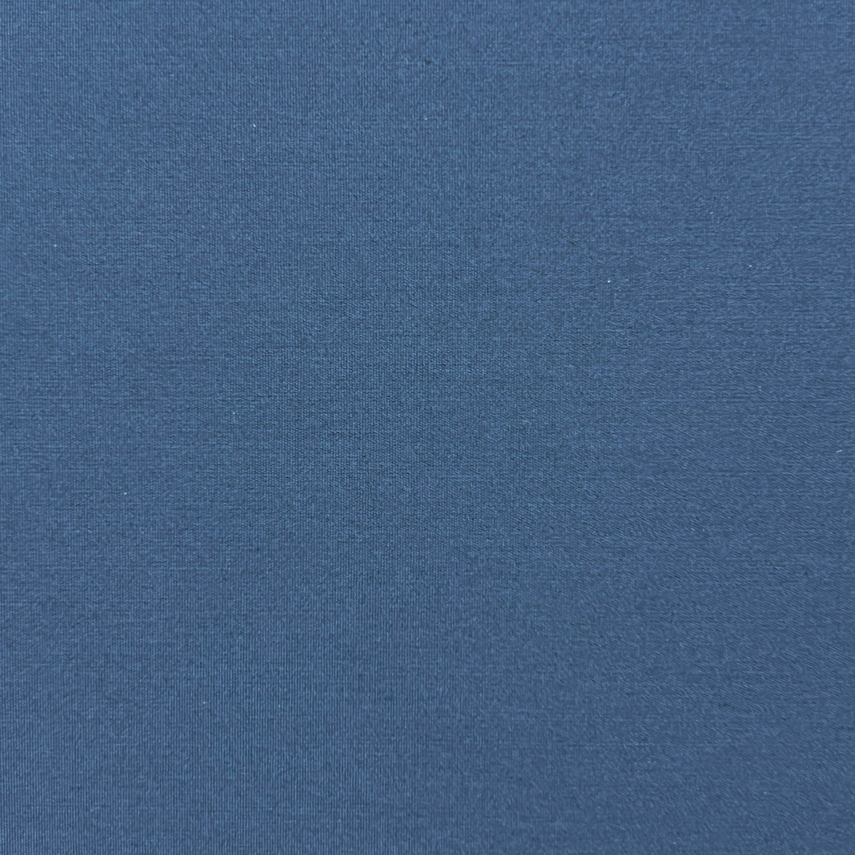 A close-up of a solid slate blue textured fabric surface.