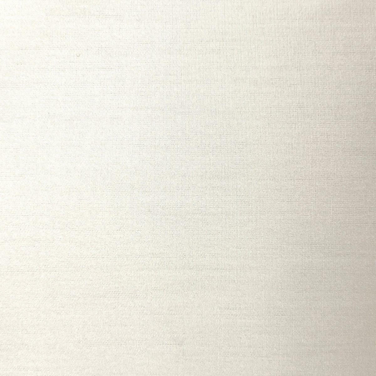 A close-up of a light beige or off-white textured fabric surface with subtle horizontal weave lines.