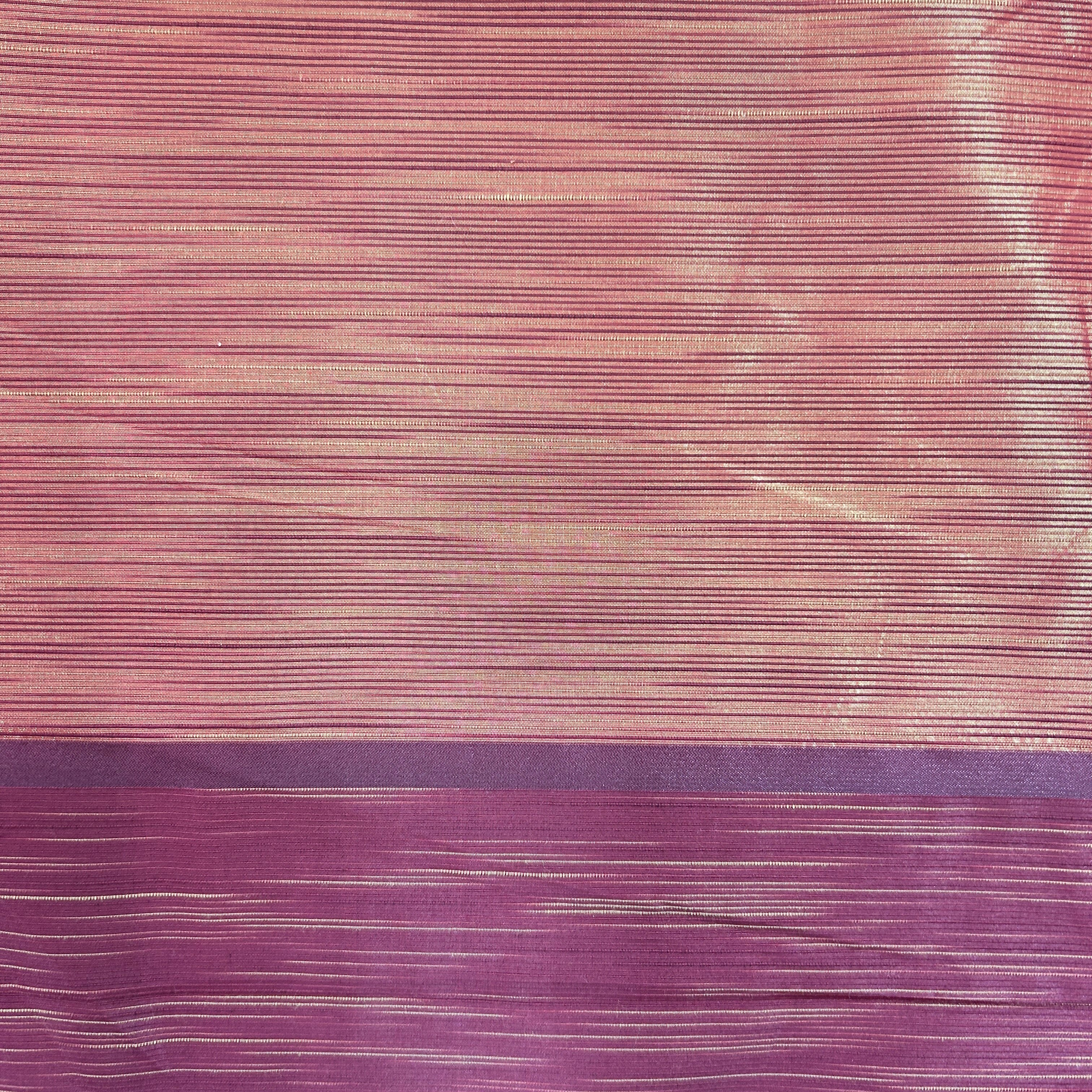 A close-up of a textured fabric with horizontal fine stripes, featuring a color-blocked design with a light pink upper section and a darker purple lower section.