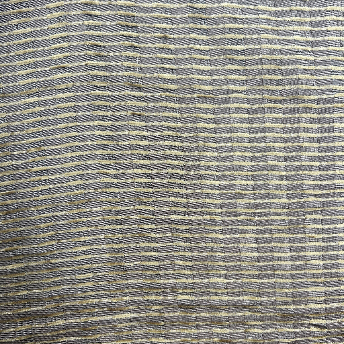 A close-up of a woven fabric texture featuring a gray base with horizontal stripes of cream and gold.