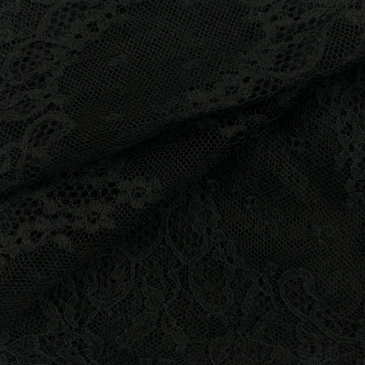 Black lace fabric with an intricate floral pattern, shown draped to highlight its texture and transparency.