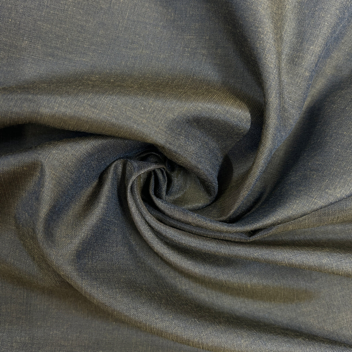 A close-up of draped fabric with a subtle woven texture, shown in a spiral fold pattern. The color is a muted slate gray with a slight cool blue undertone.
