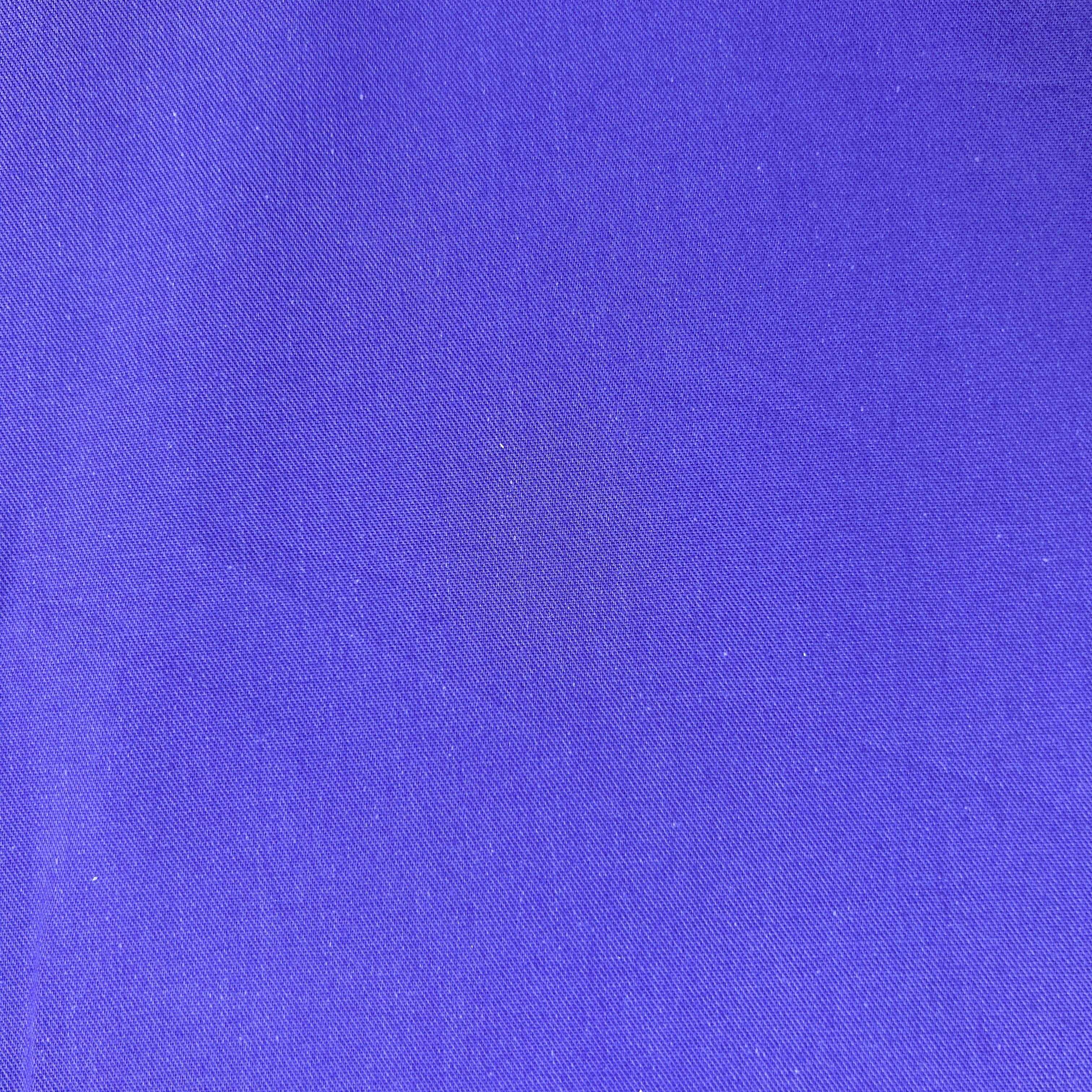 A close-up of a solid purple fabric texture with a fine woven pattern.