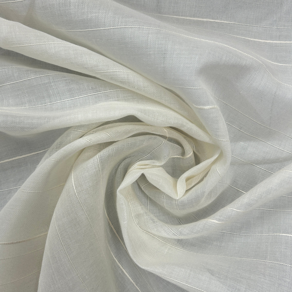 A close-up of draped off-white fabric with a subtle woven texture and thin vertical light stripes, arranged in a spiral fold.