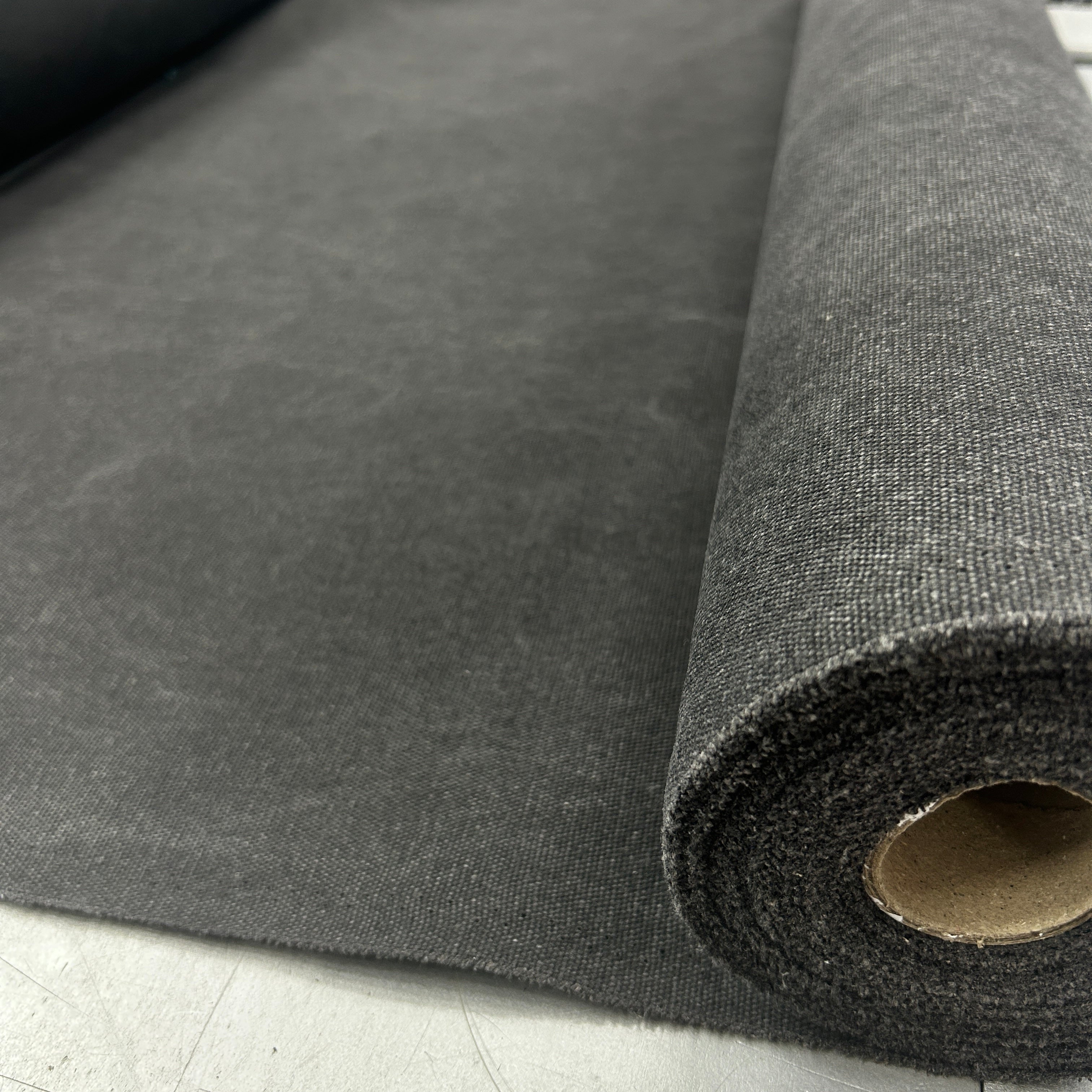 Roll of black poly cotton heavy waxed canvas stiff fabric for bag making.